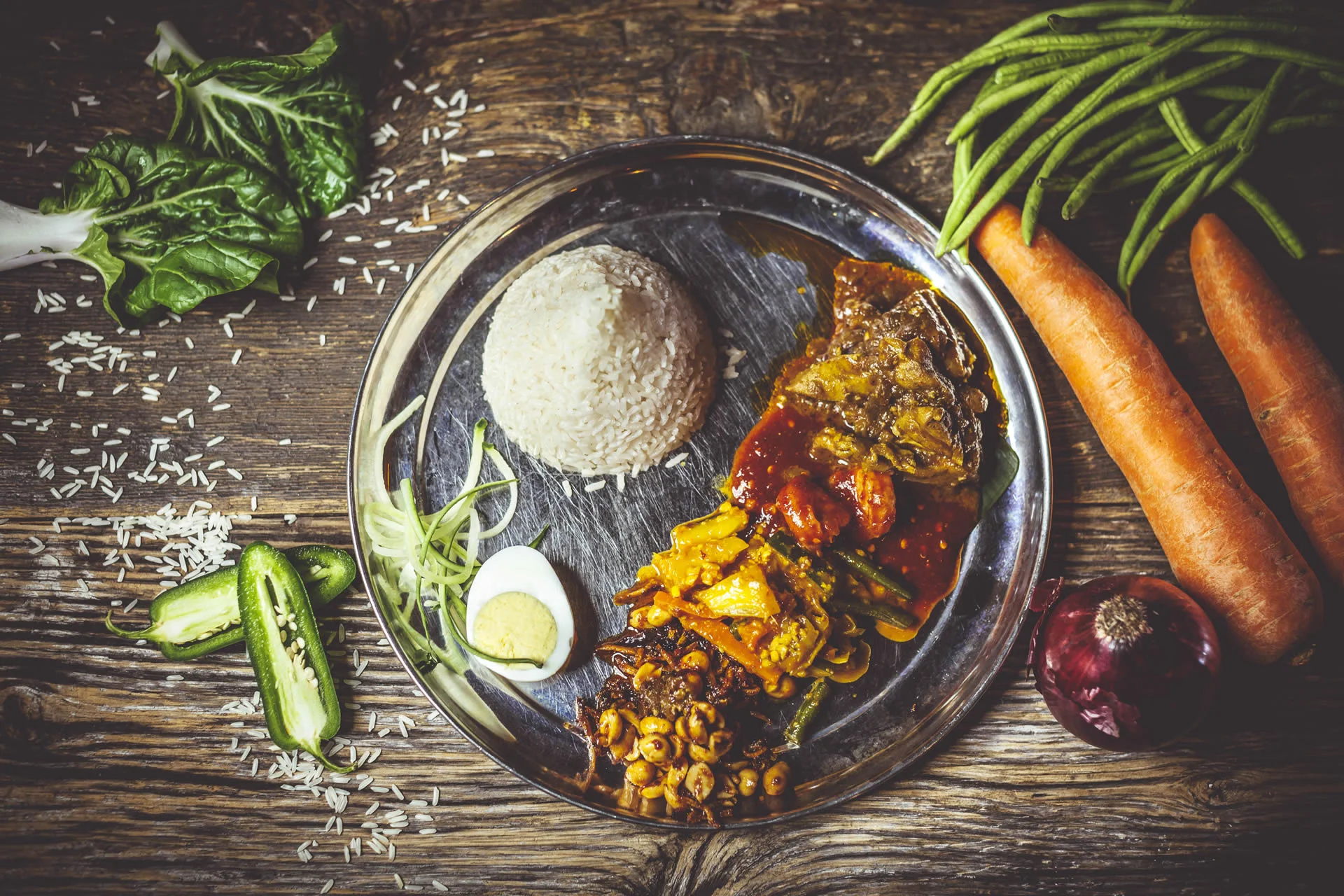Traditional Malaysian nasi lemak served on a stainless steel plate
