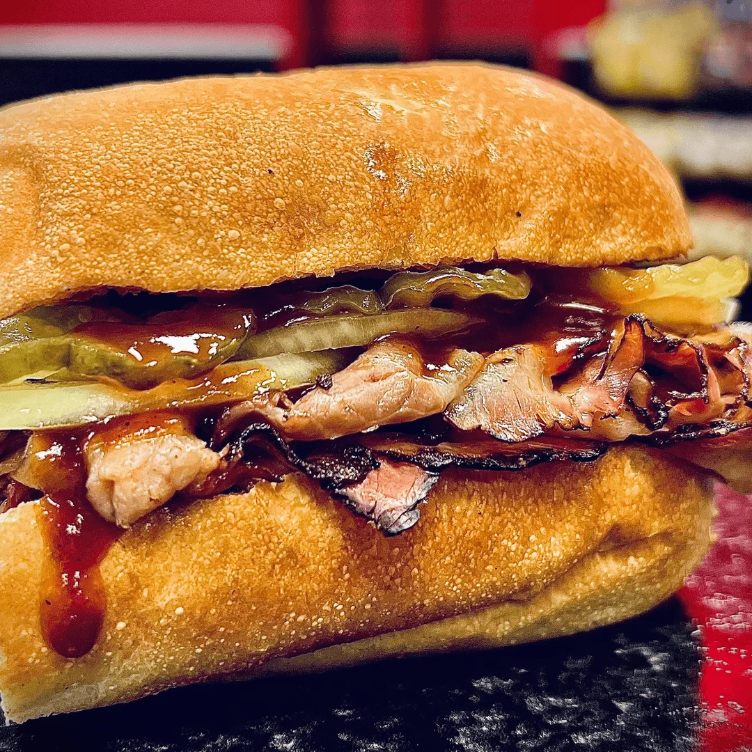 Smoked brisket sandwich with barbecue sauce and pickles