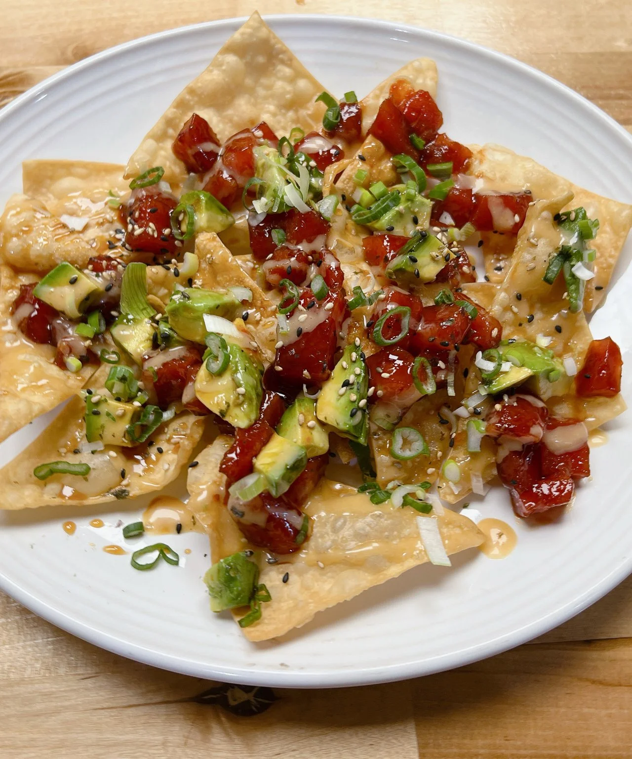 Crispy Asian nachos topped with fresh avocado and salsa