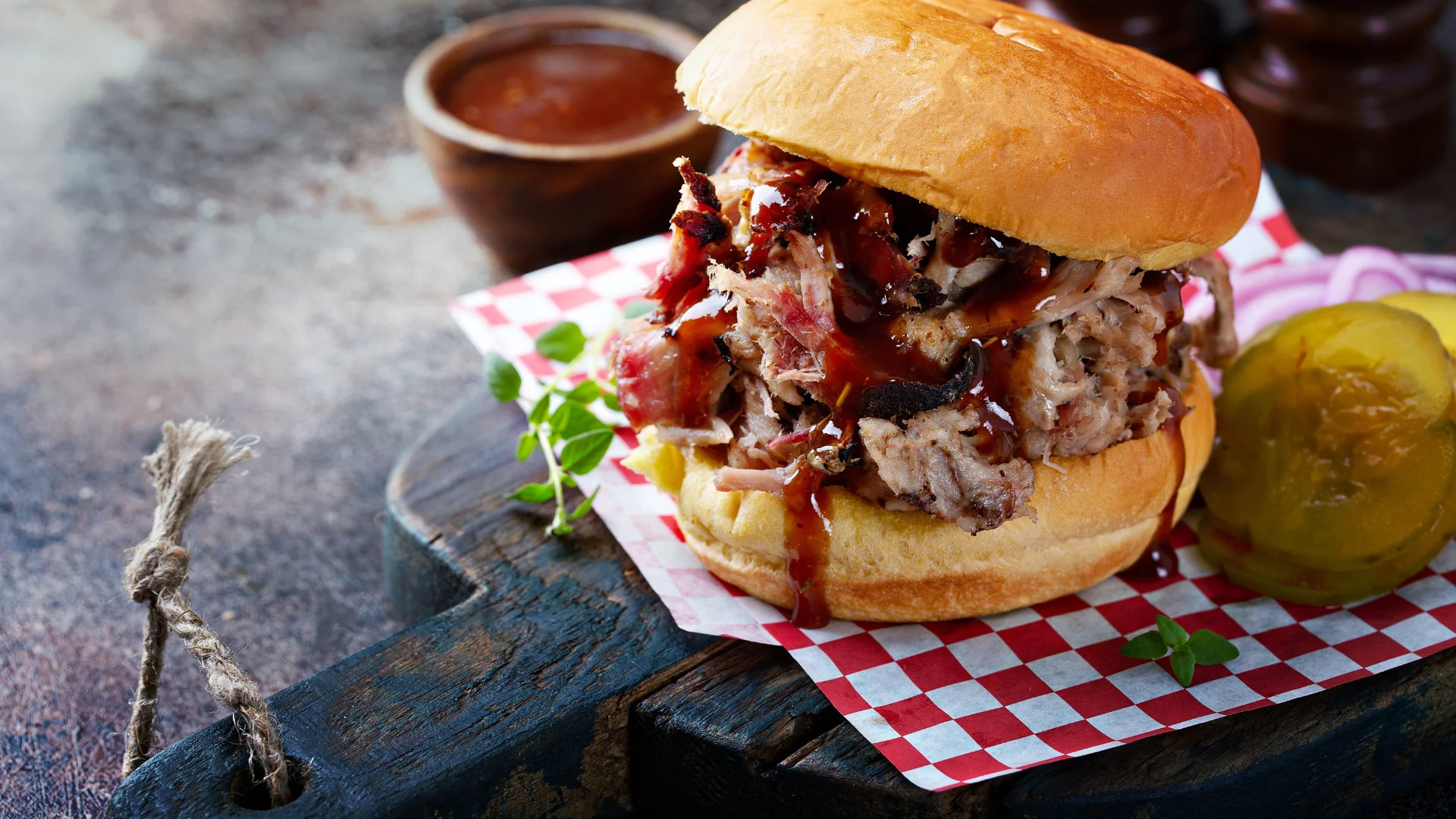 Pulled pork sandwich with barbecue sauce on a wooden board