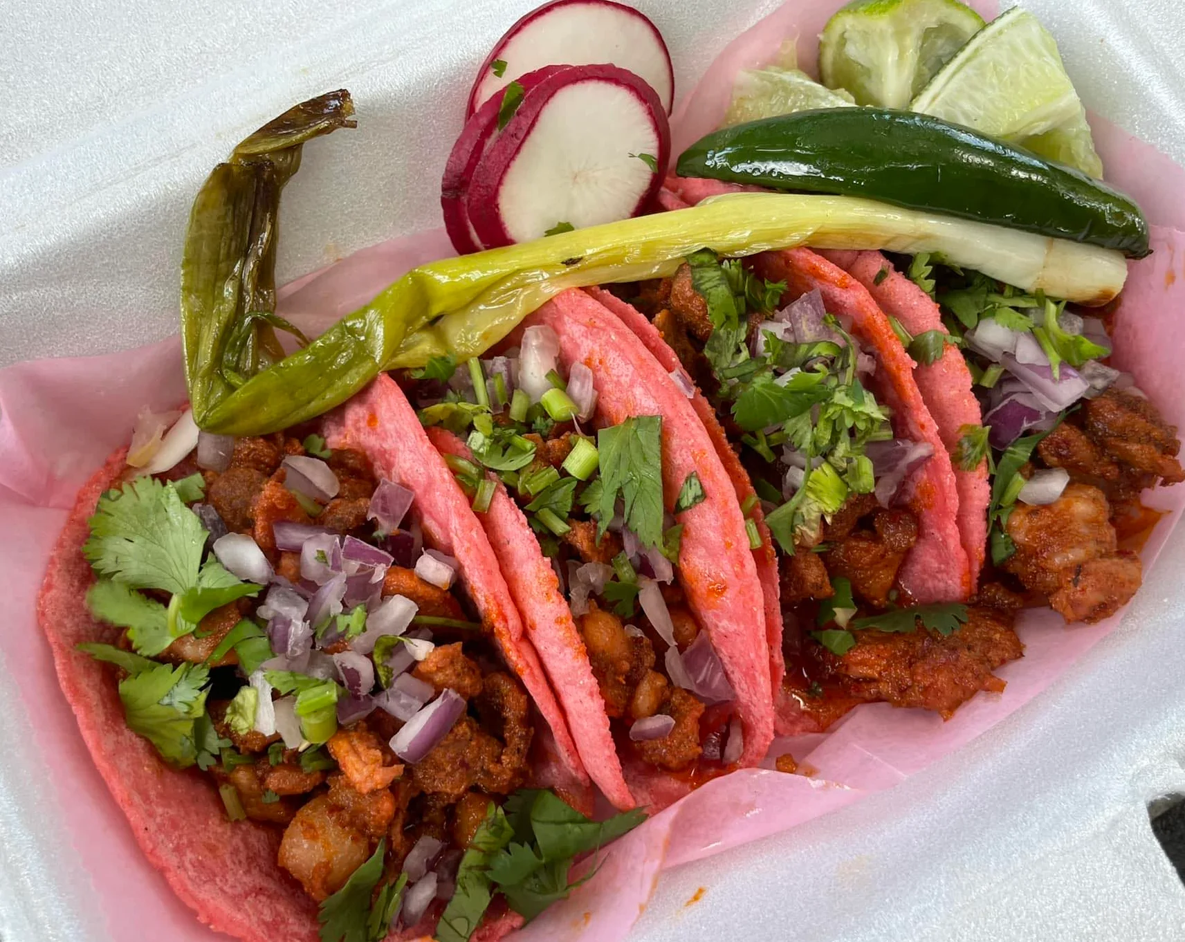 Colorful Mexican street tacos with vibrant pink tortillas