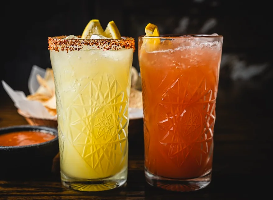 Colorful cocktails with citrus garnishes at a vibrant bar