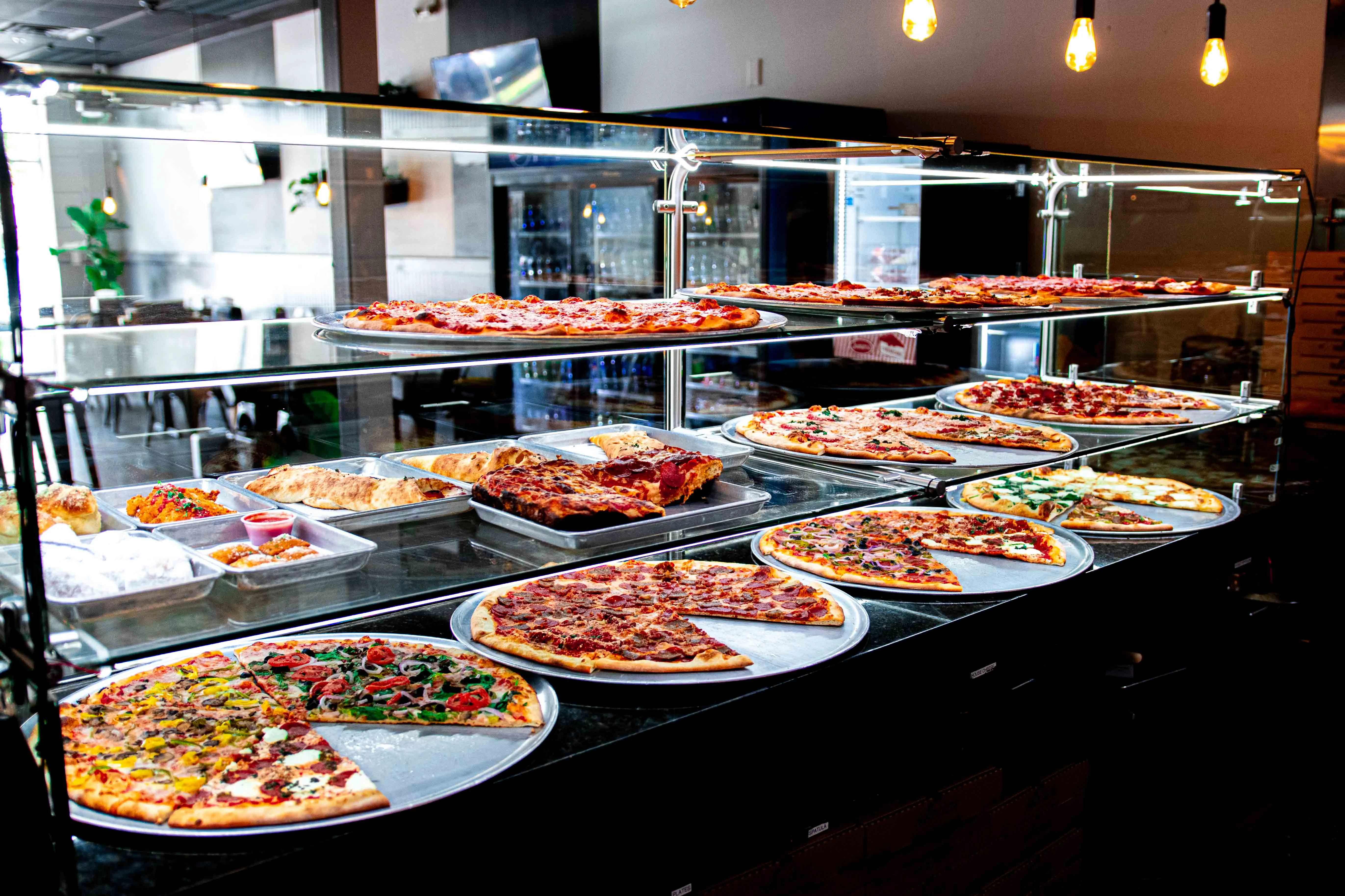 Variety of pizzas displayed in a modern pizzeria