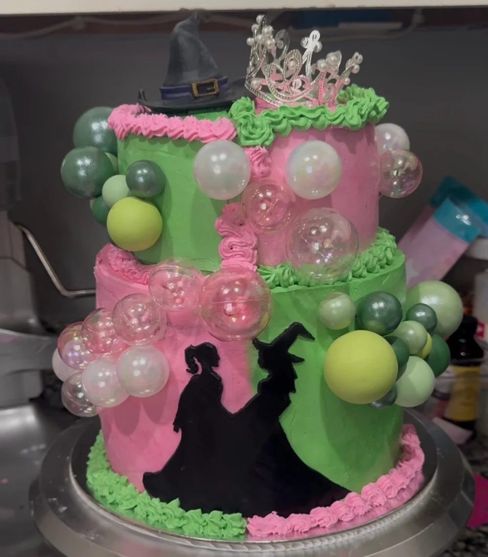 Colorful birthday cake with witch and princess silhouettes and bubble decorations