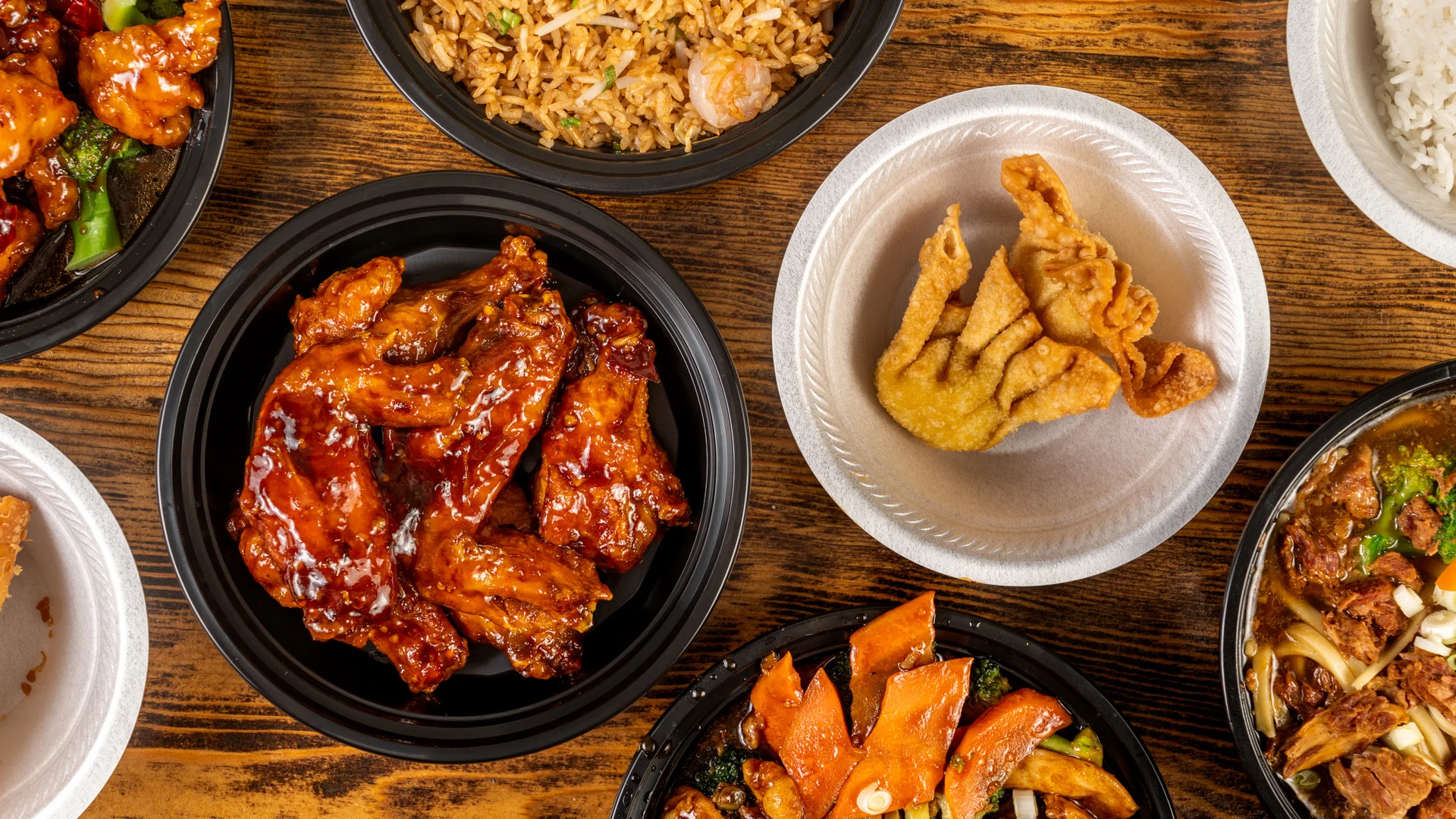Assorted Chinese takeout dishes including chicken wings and fried wontons