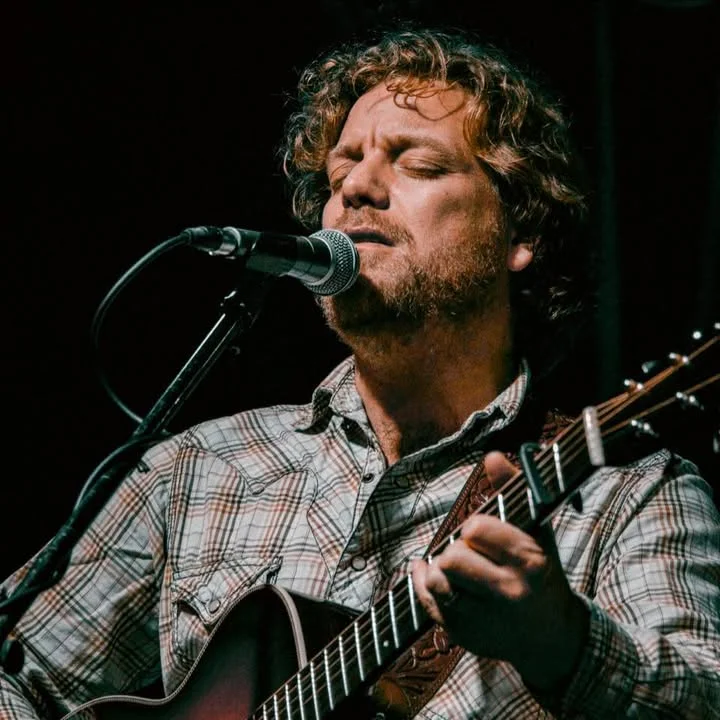 Musician performing live with guitar and microphone