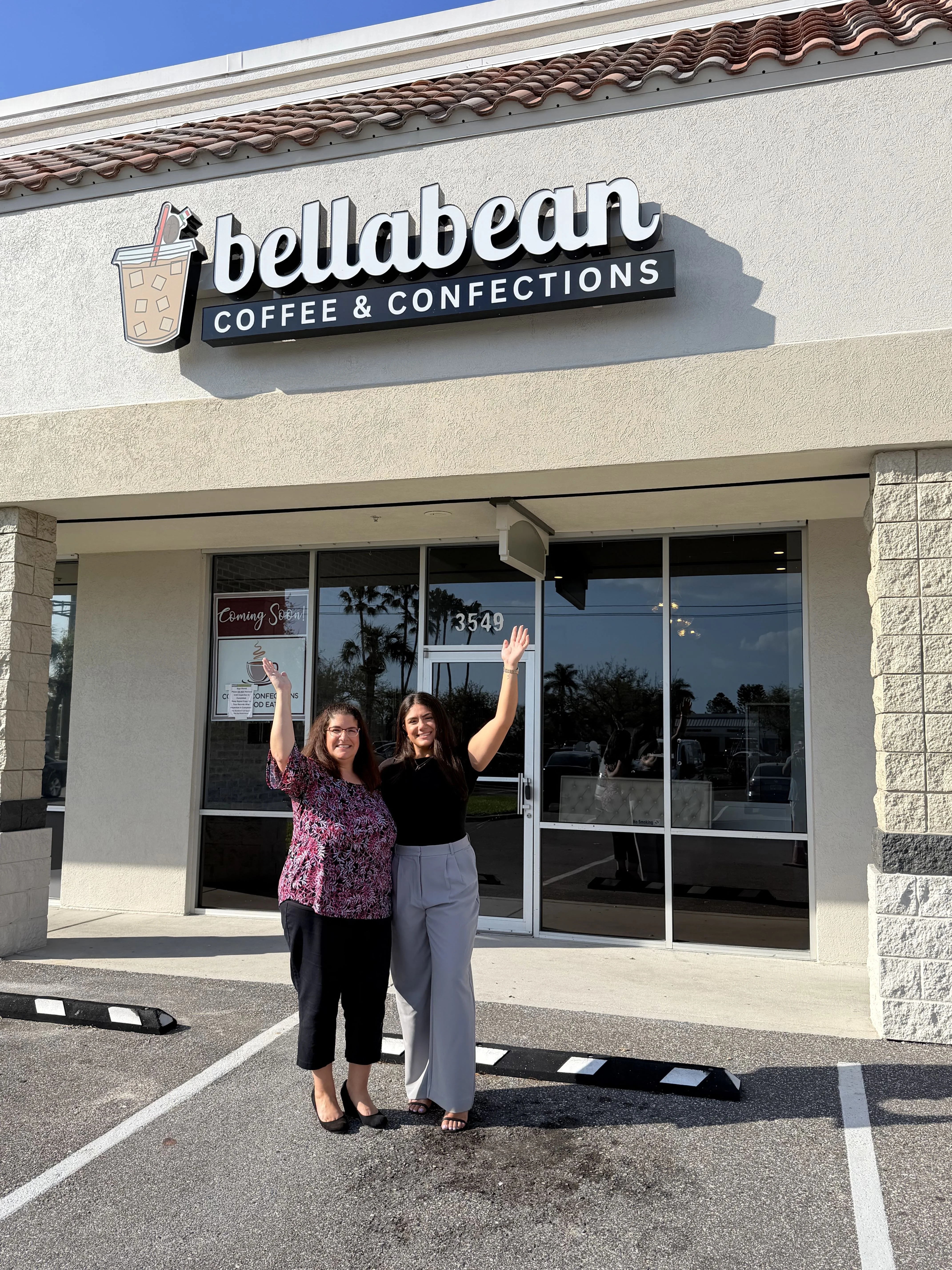Exterior of Bellabean Coffee & Confections with two women waving