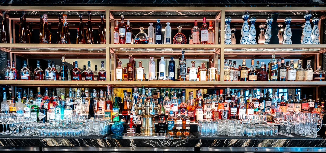 Well-stocked bar with a variety of spirits and glassware