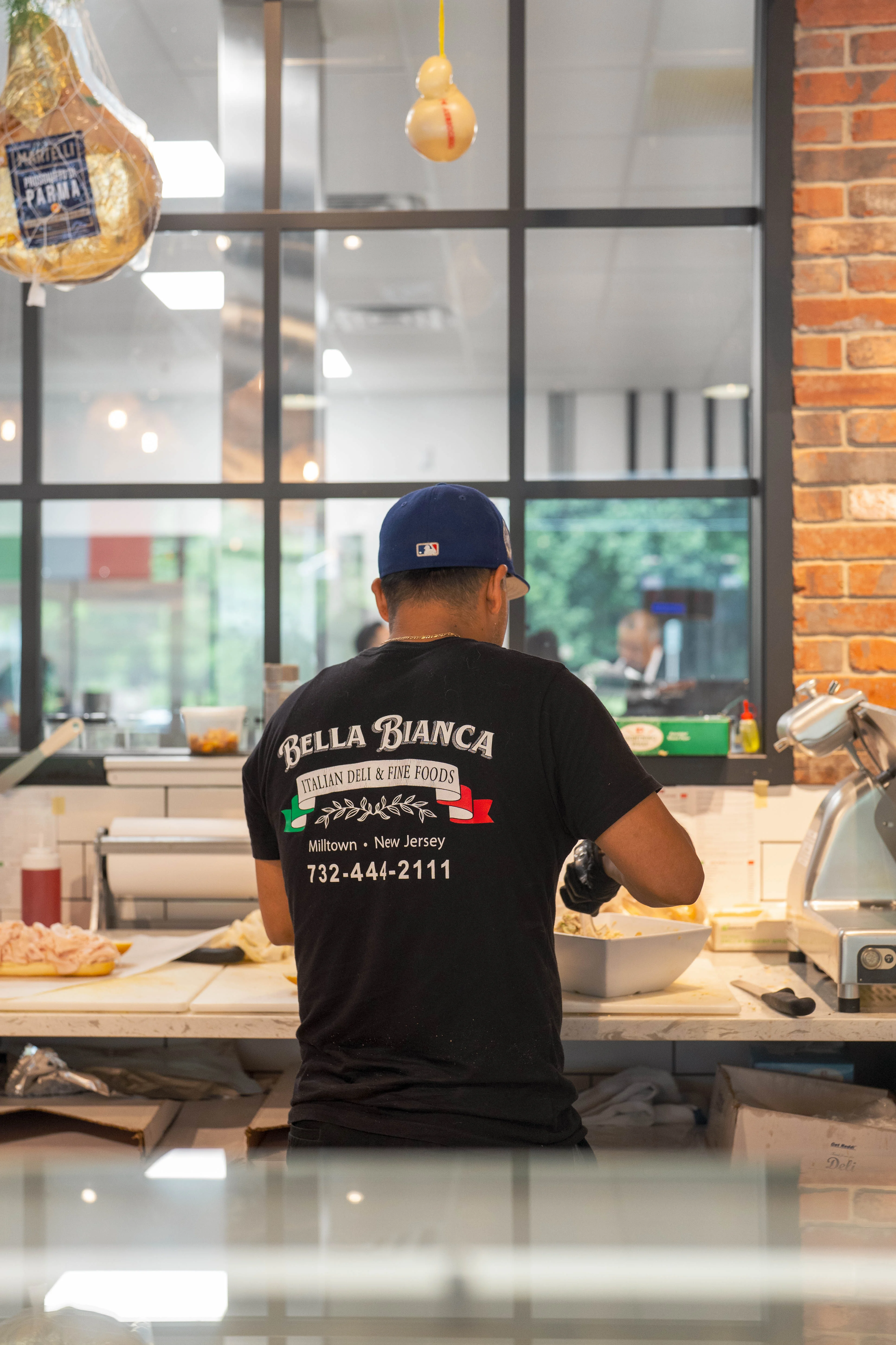 Italian deli worker preparing fresh pasta in a vibrant kitchen
