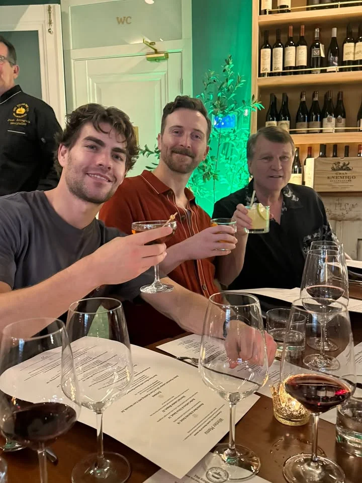 Friends toasting with cocktails at a cozy restaurant table