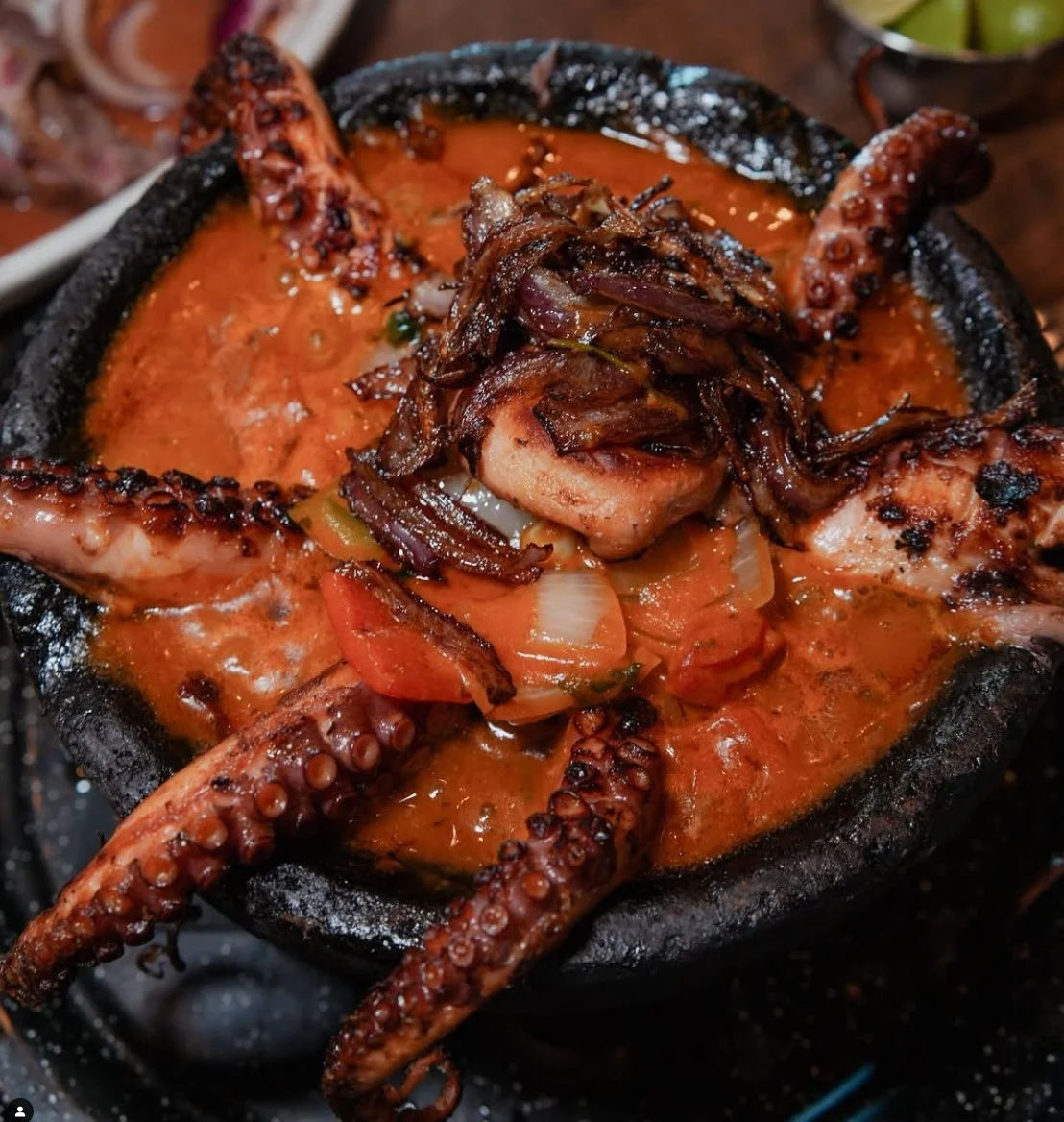 Mexican seafood dish of octopus in a hot stone bowl