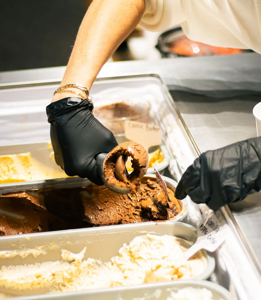 Scoop of chocolate gelato being served in a restaurant
