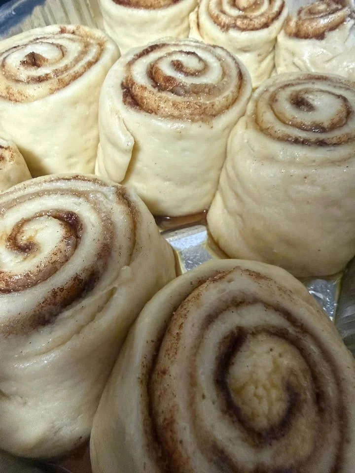 Freshly prepared cinnamon rolls with swirls of cinnamon and sugar, ready to be baked.