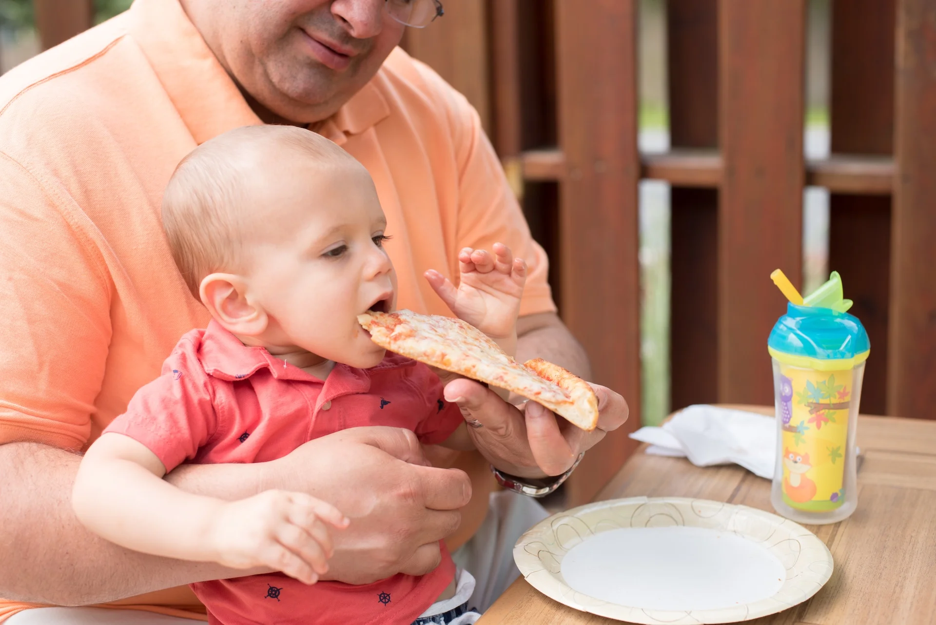 Child enjoying a slice of Margherita pizza outdoors