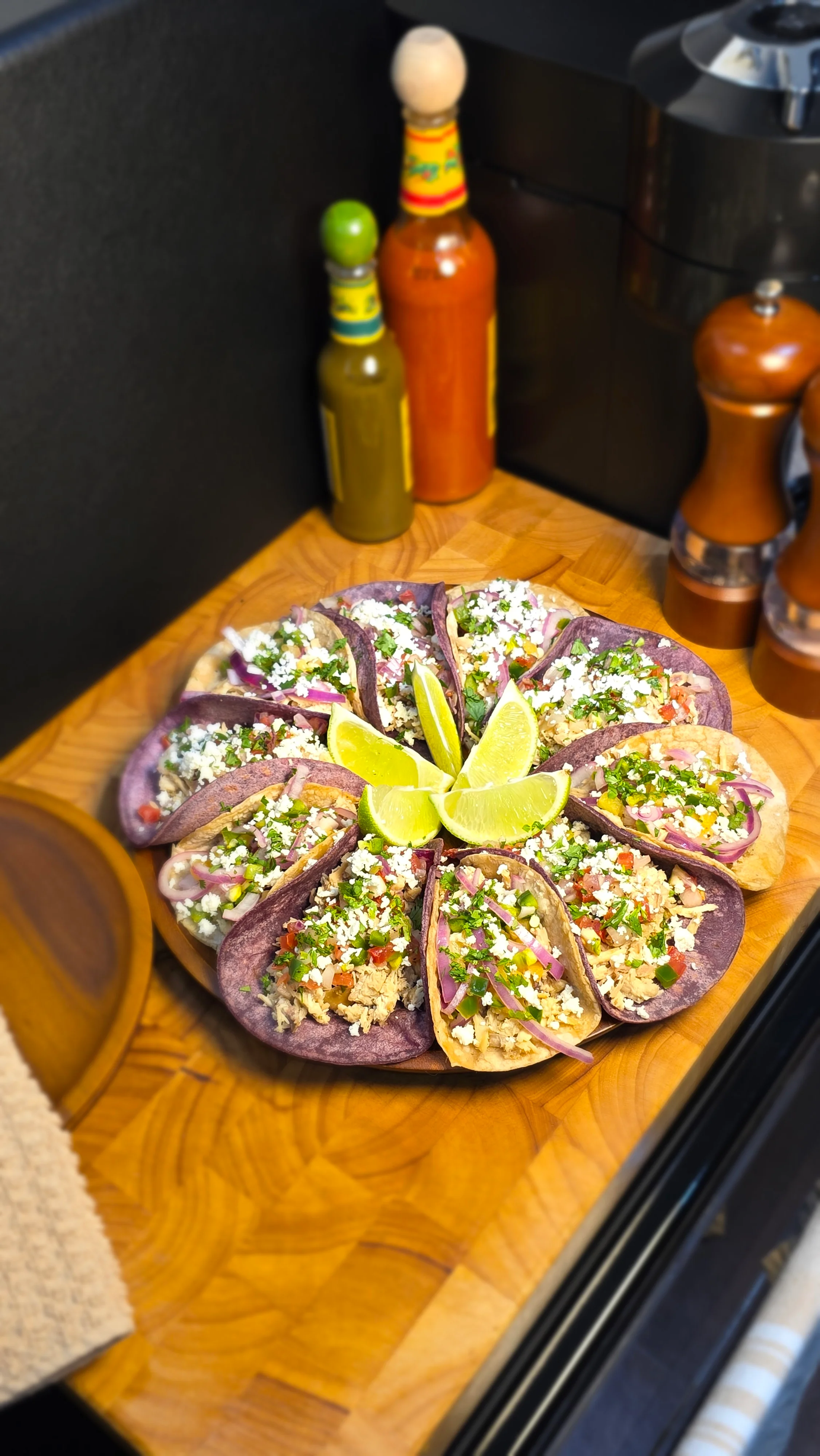 Colorful platter of Mexican tacos with lime wedges