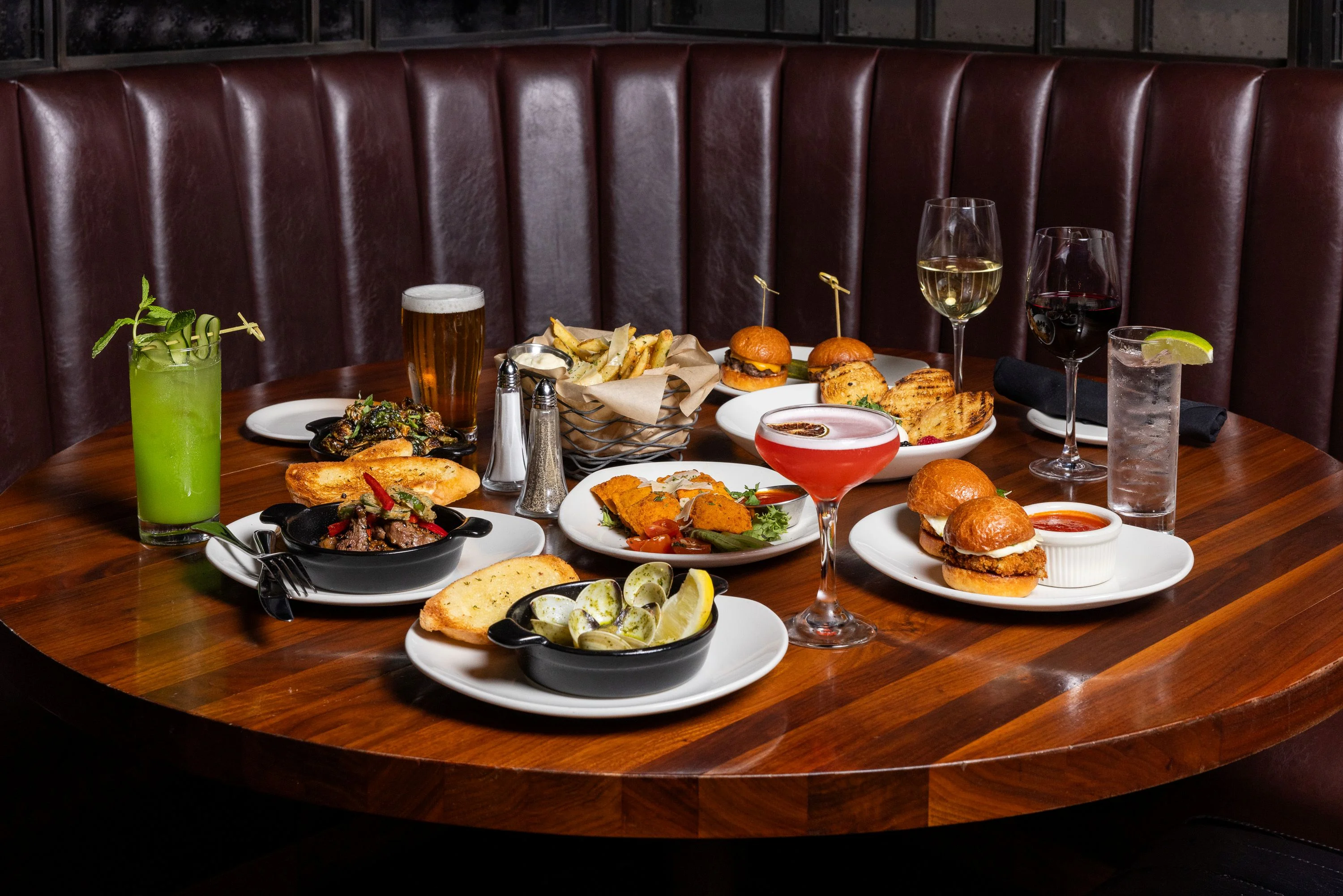 A variety of delicious dishes including fries, clams, and a cocktail.