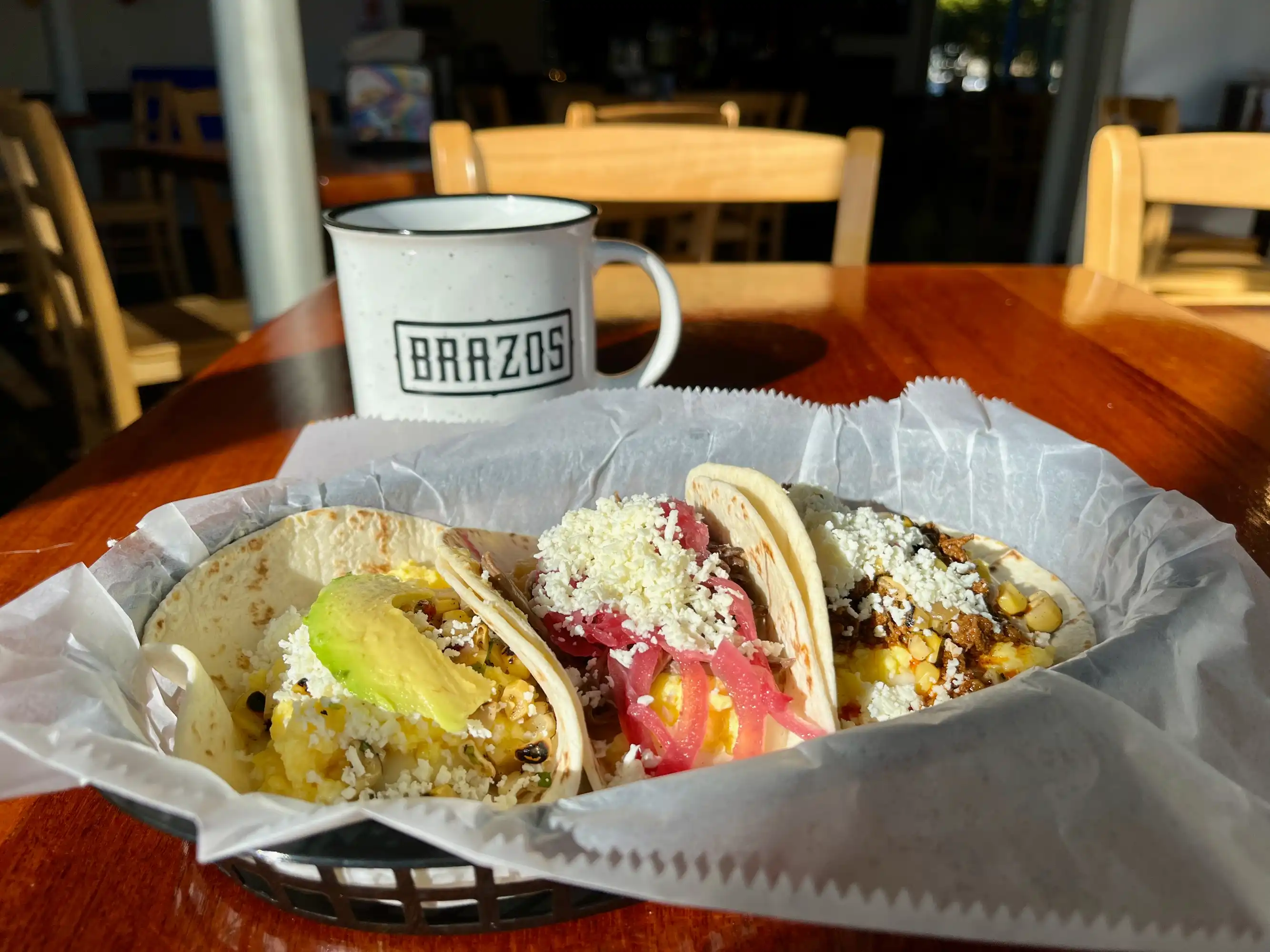 Three brerakfast tacos and a cup of coffee at Brazos Tacos in the IX Art Park in Charlottesville, VA