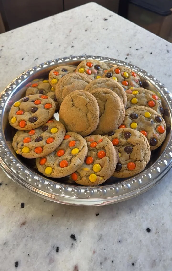 Two freshly baked cookies on a marble surface, showcasing a golden-brown color.
