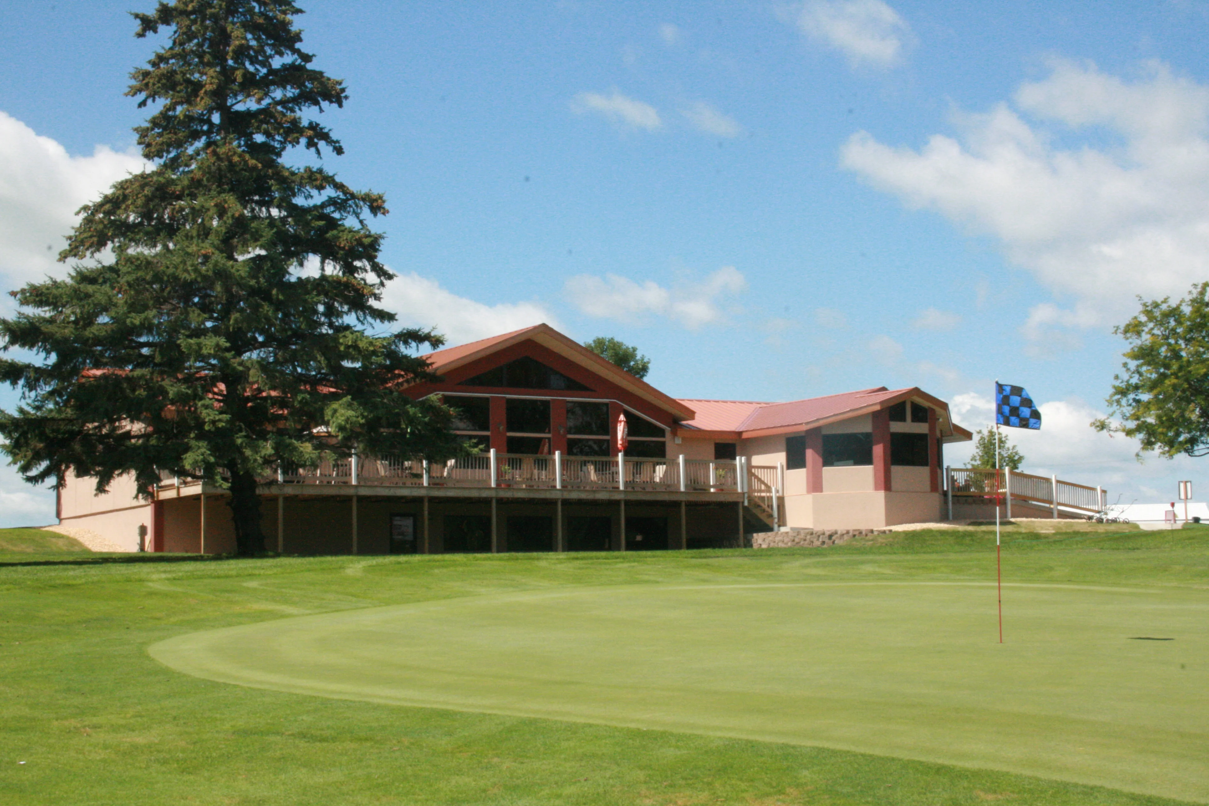 Golf course clubhouse with green lawn and blue sky