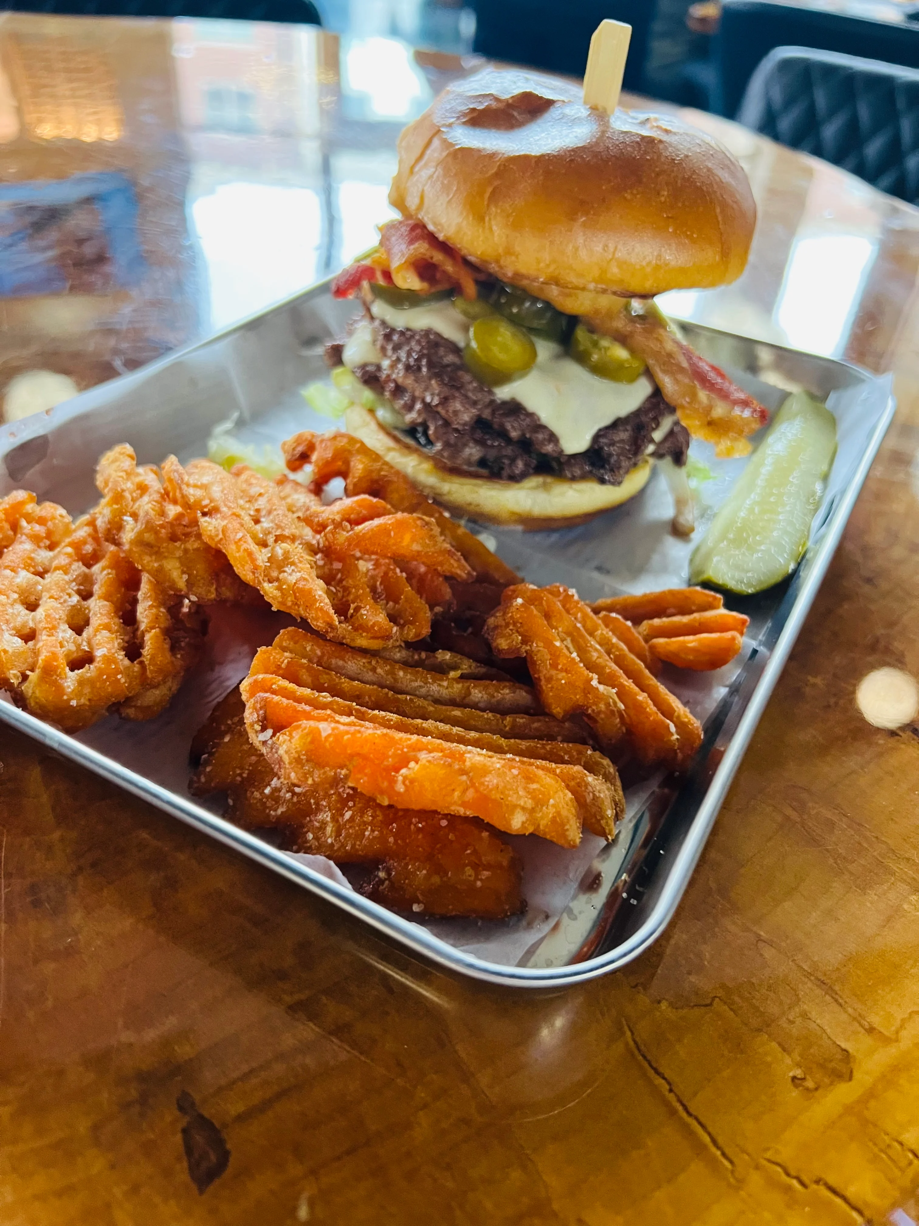 Juicy cheeseburger with bacon and pickles on a bun