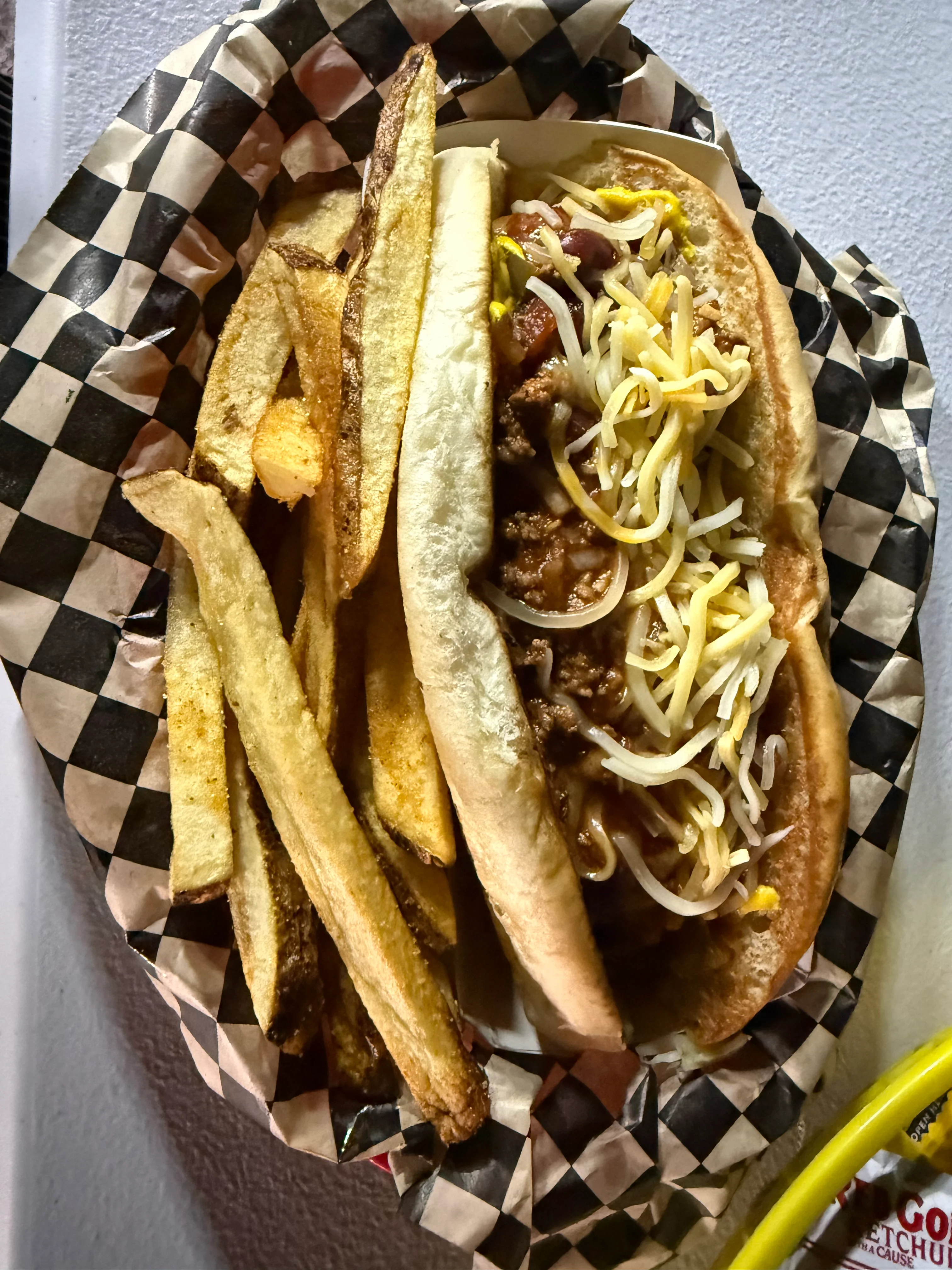 Chili cheese dog with fries in a casual dining setting