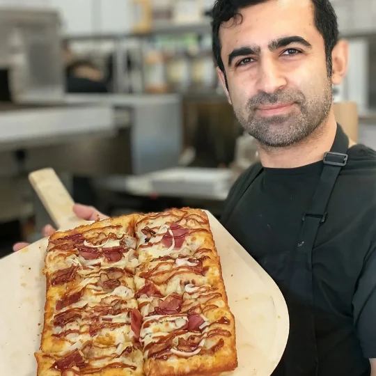 Freshly baked pepperoni pizza on a wooden peel
