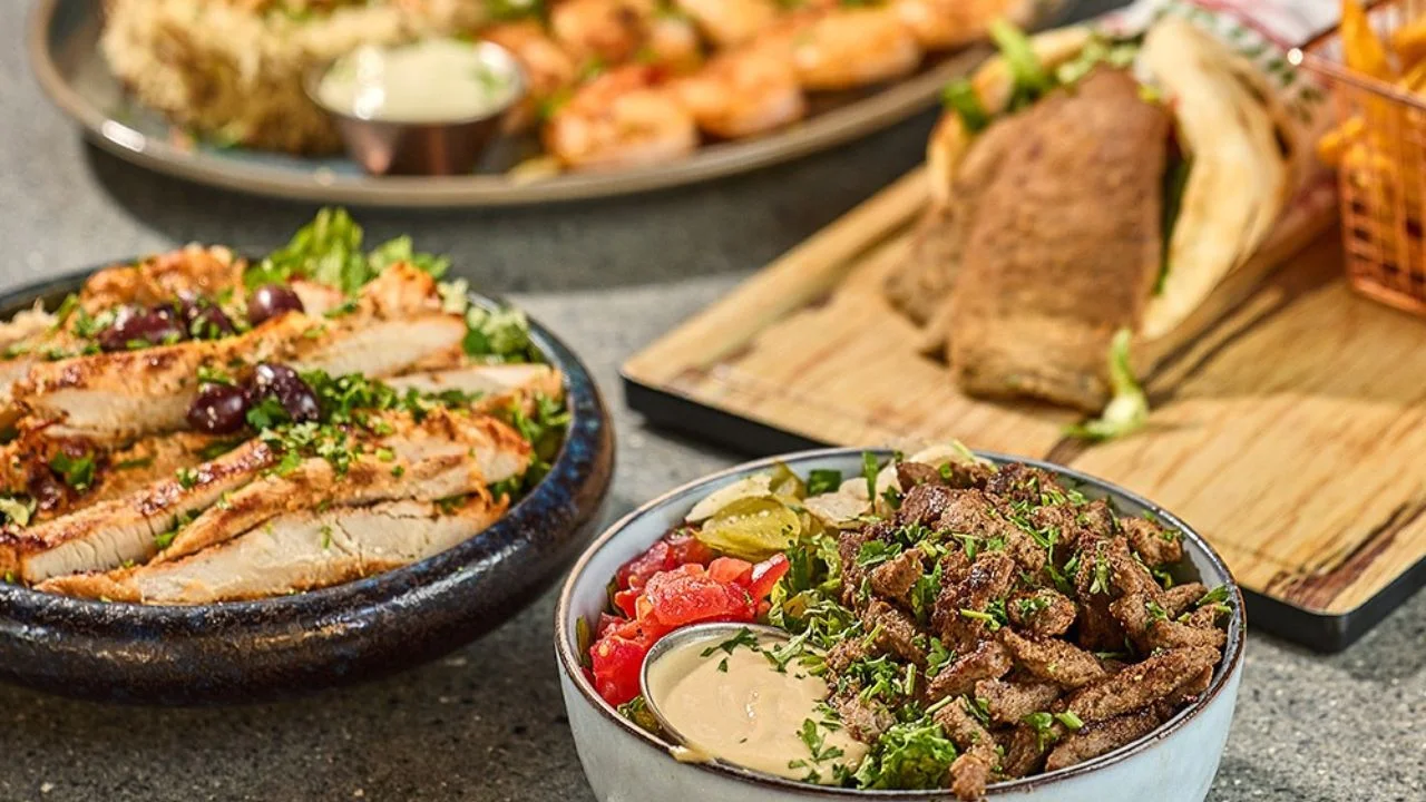 Grilled meats and bowls seasoned with fresh Mediterranean herbs, served with salad and pita.