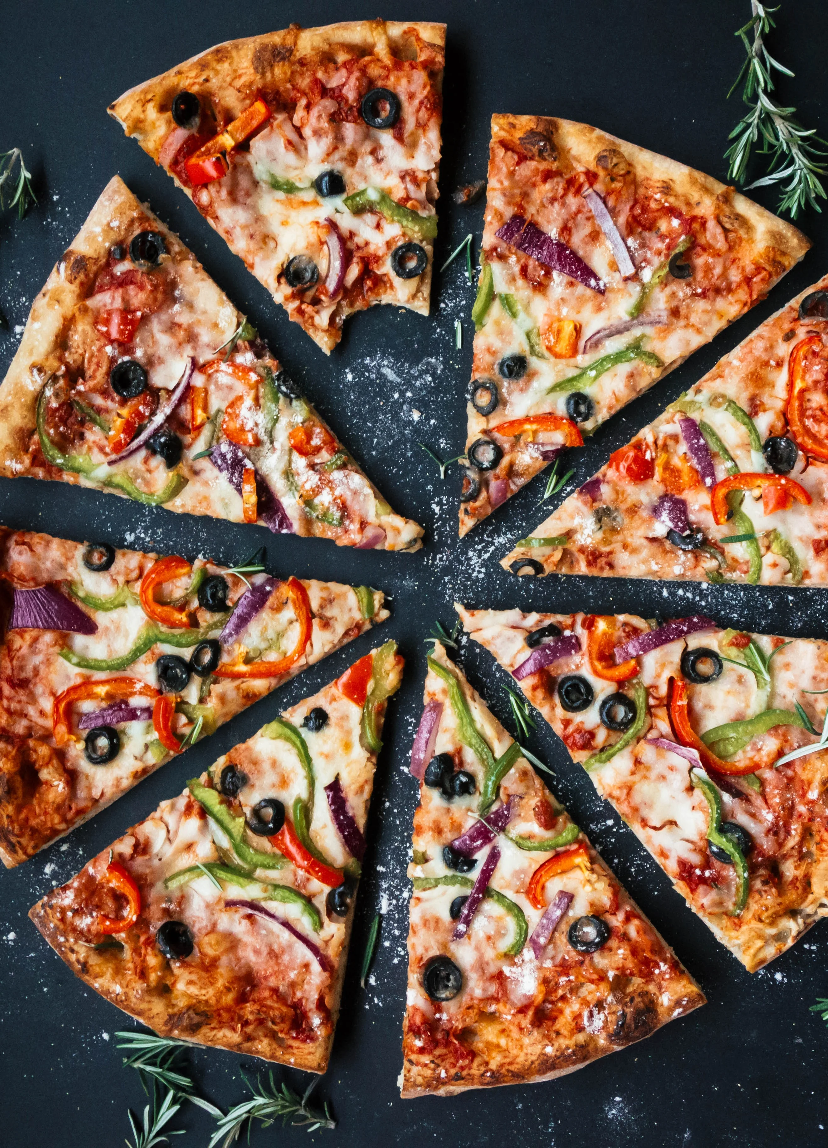 Colorful vegetable pizza on a black background