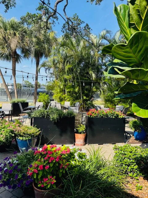 Charming outdoor dining area with lush greenery and colorful flowers