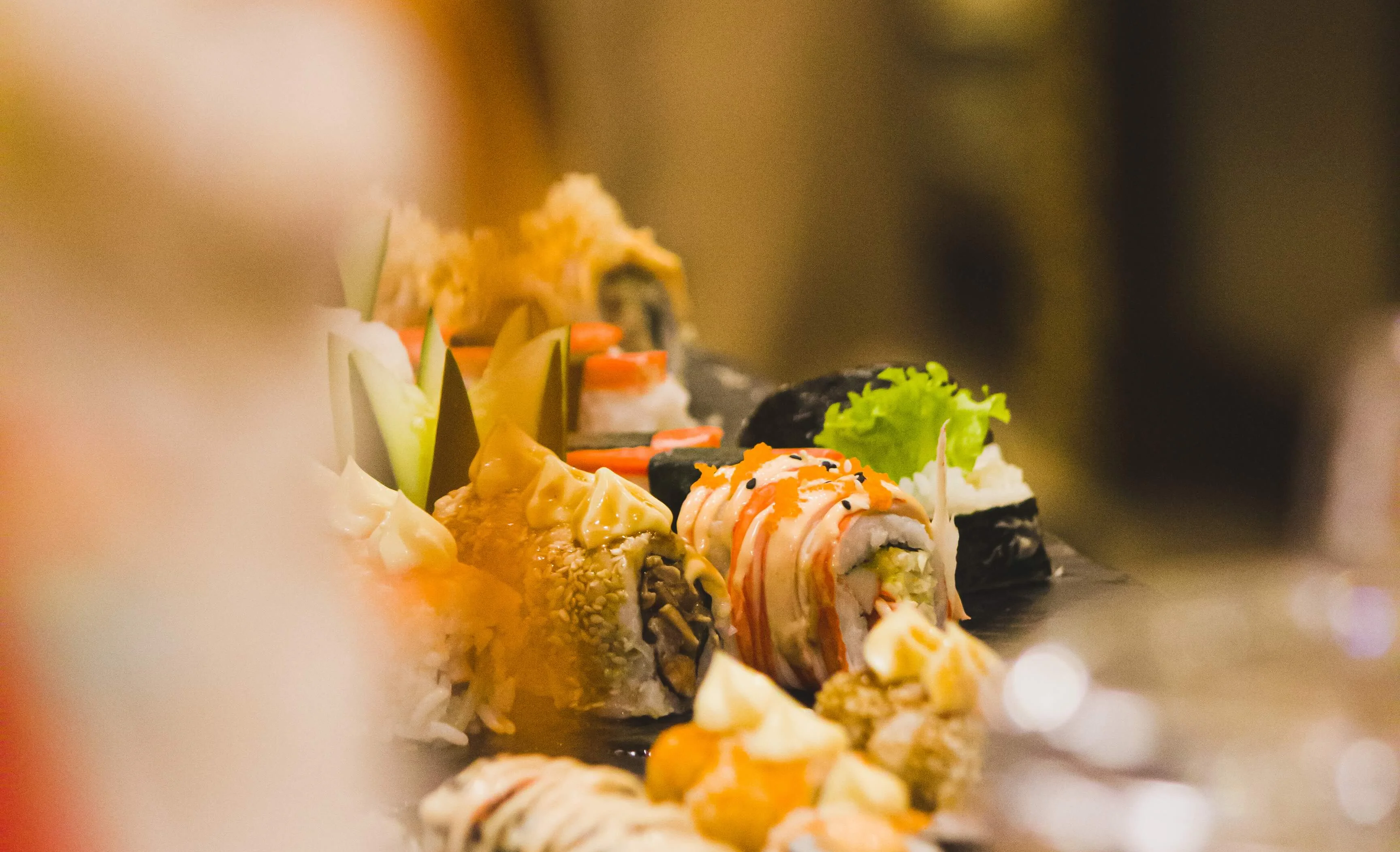 Assorted sushi platter featuring various rolls and garnishes