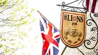 A pub sign featuring the name 'Three Lions' with a lion motif, accompanied by a British flag in the background. The setting evokes a traditional British pub atmosphere.