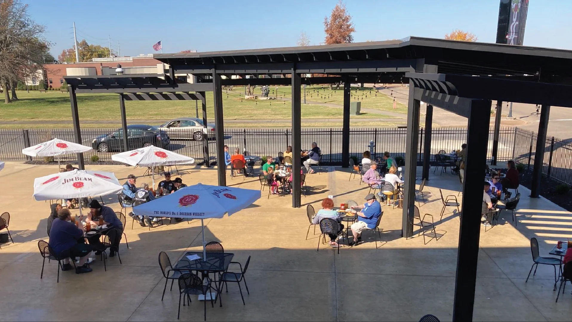 Outdoor dining area with umbrellas and patrons enjoying meals