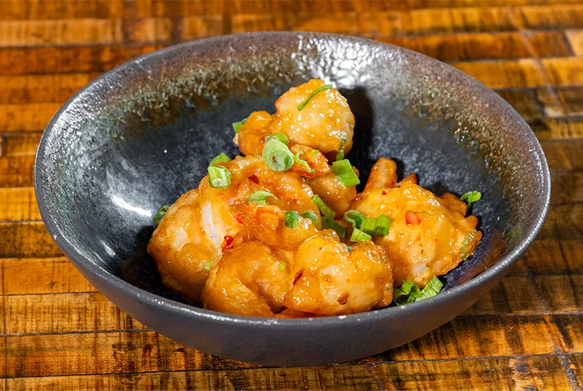 Sweet and sour shrimp in a black bowl