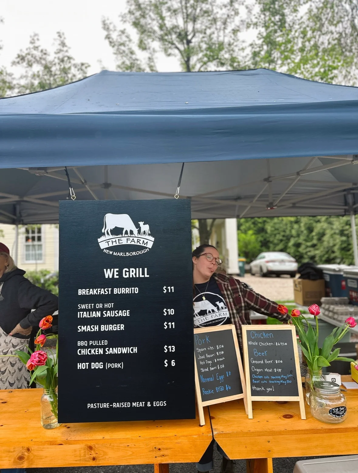 Menu board at a farm stand featuring grilled items and local produce