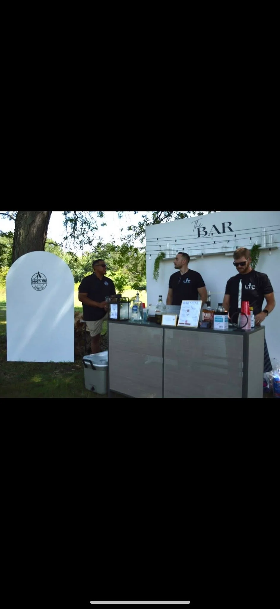 Bartenders serving drinks at a stylish outdoor bar