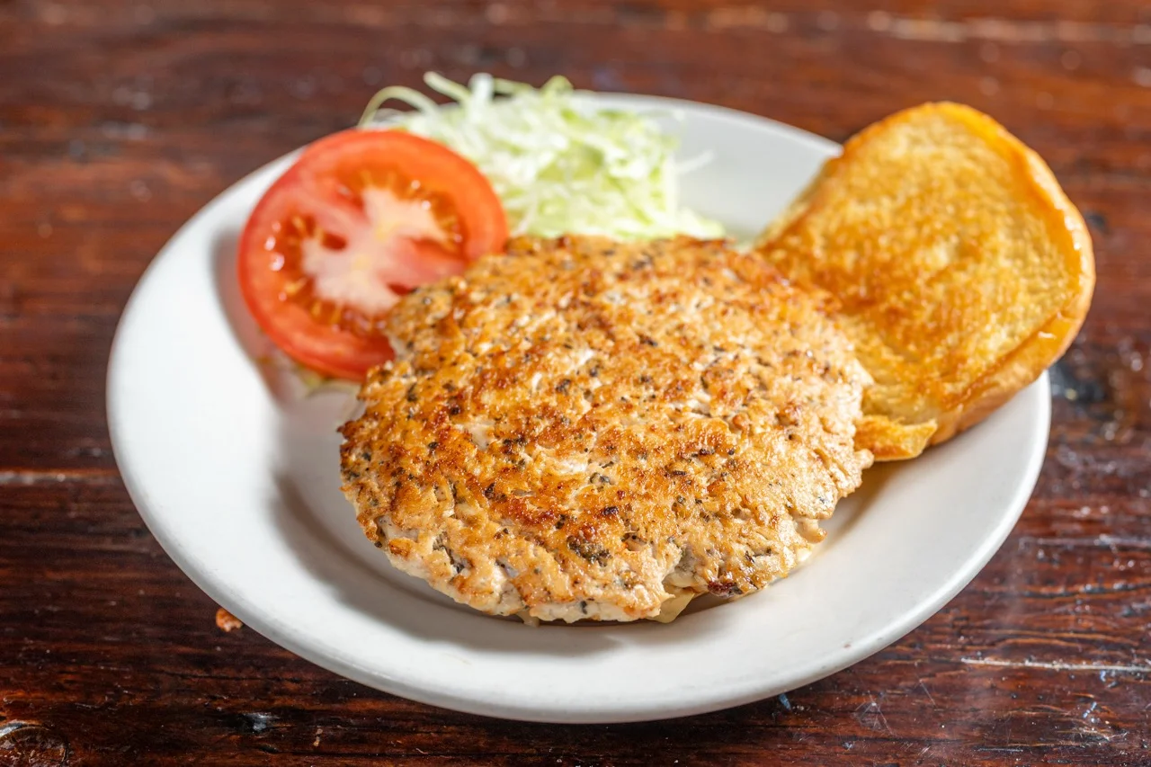 Crispy salmon burger with lettuce and tomato
