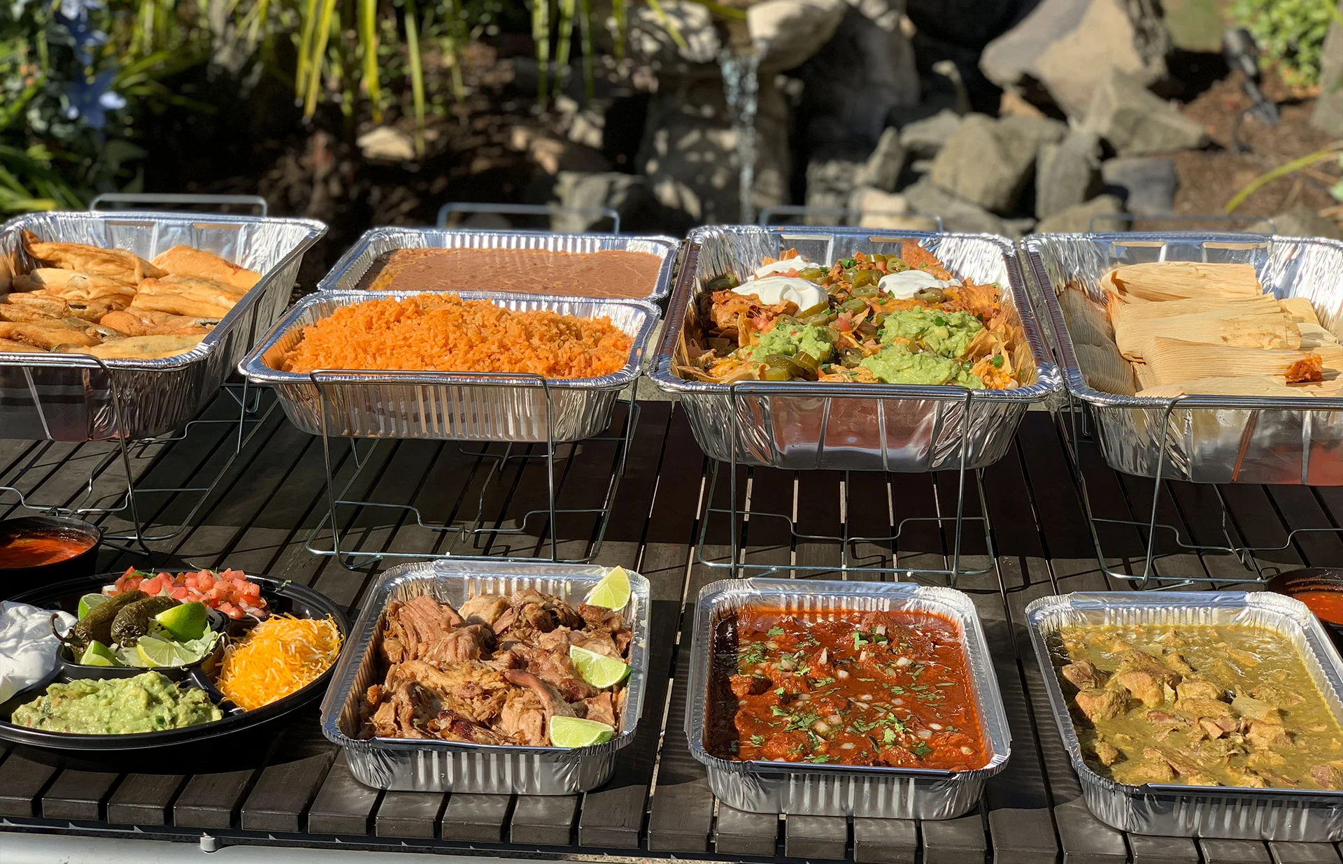 Mexican food catering table with different chaffers with food and side dishes