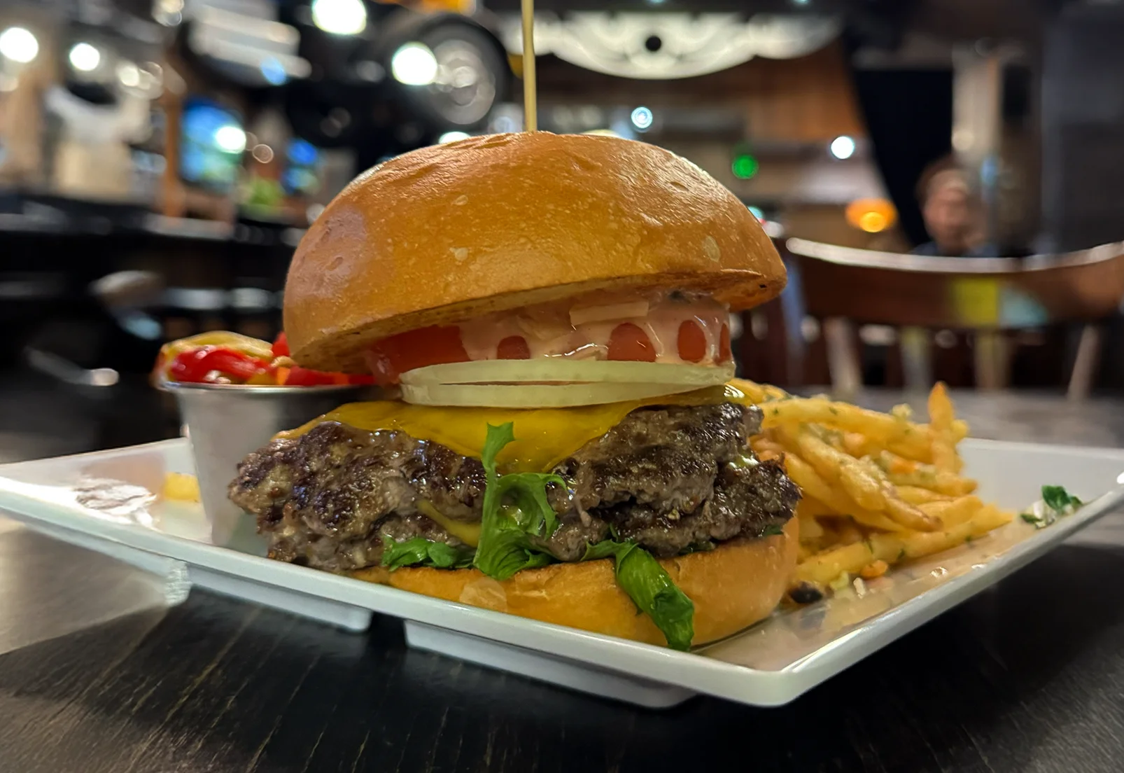 Juicy cheeseburger with lettuce and tomato in a cozy restaurant setting
