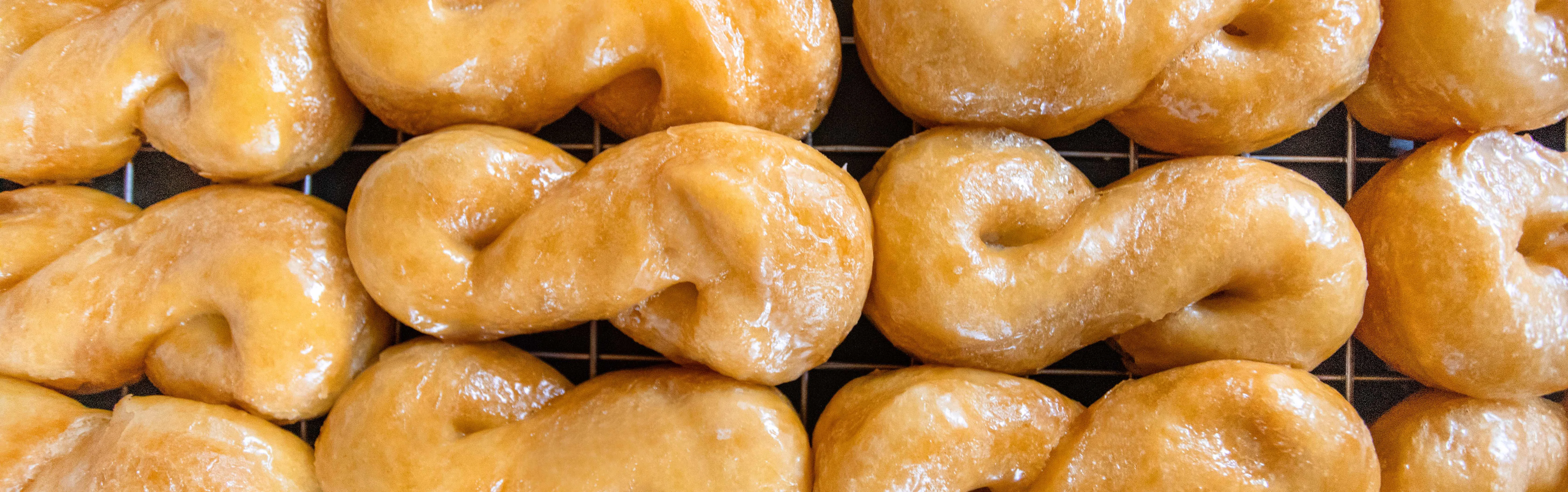 Glazed cruller donuts cooling on a rack