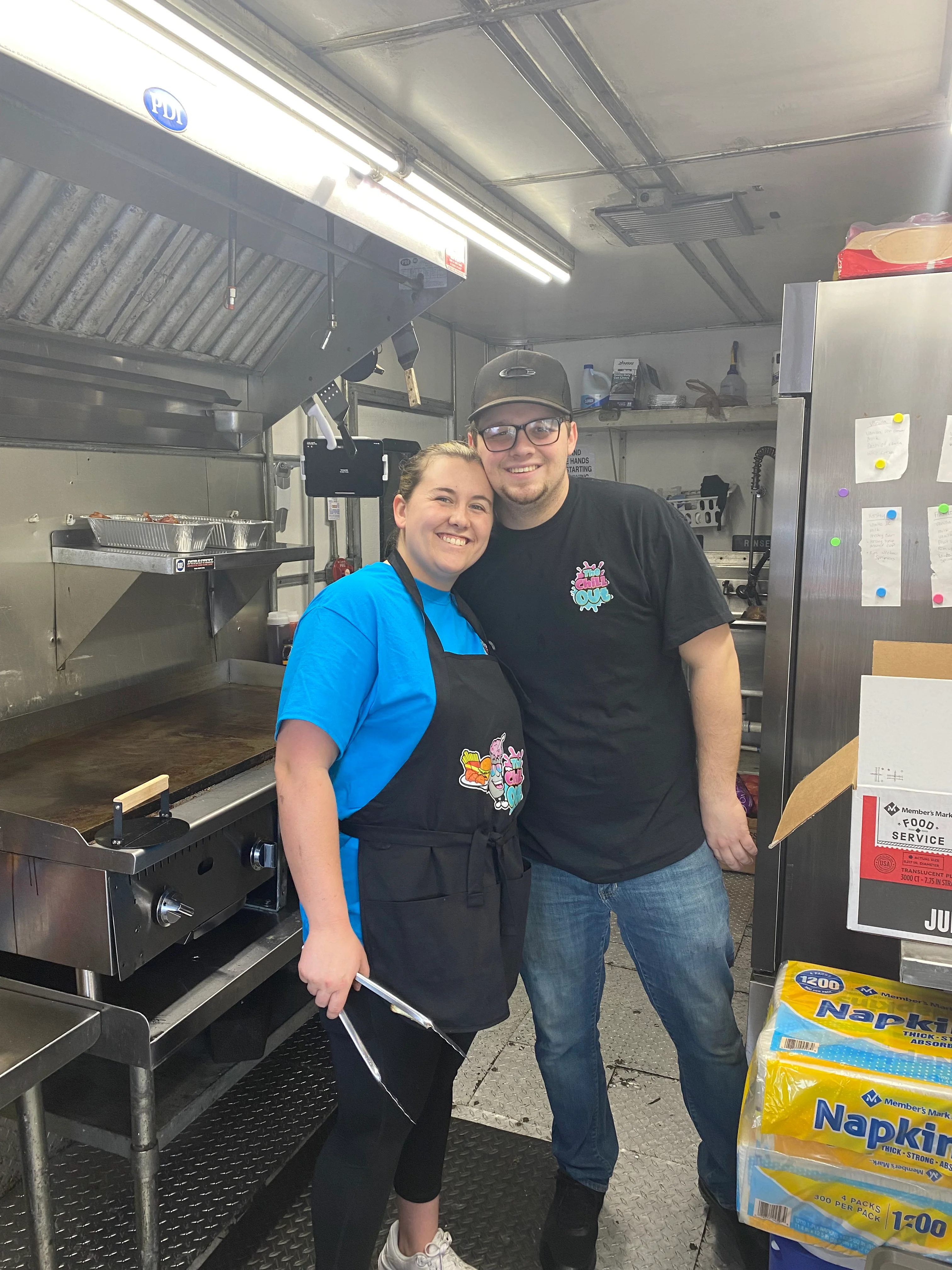 Picture of the owners standing in the original Chill Out food truck