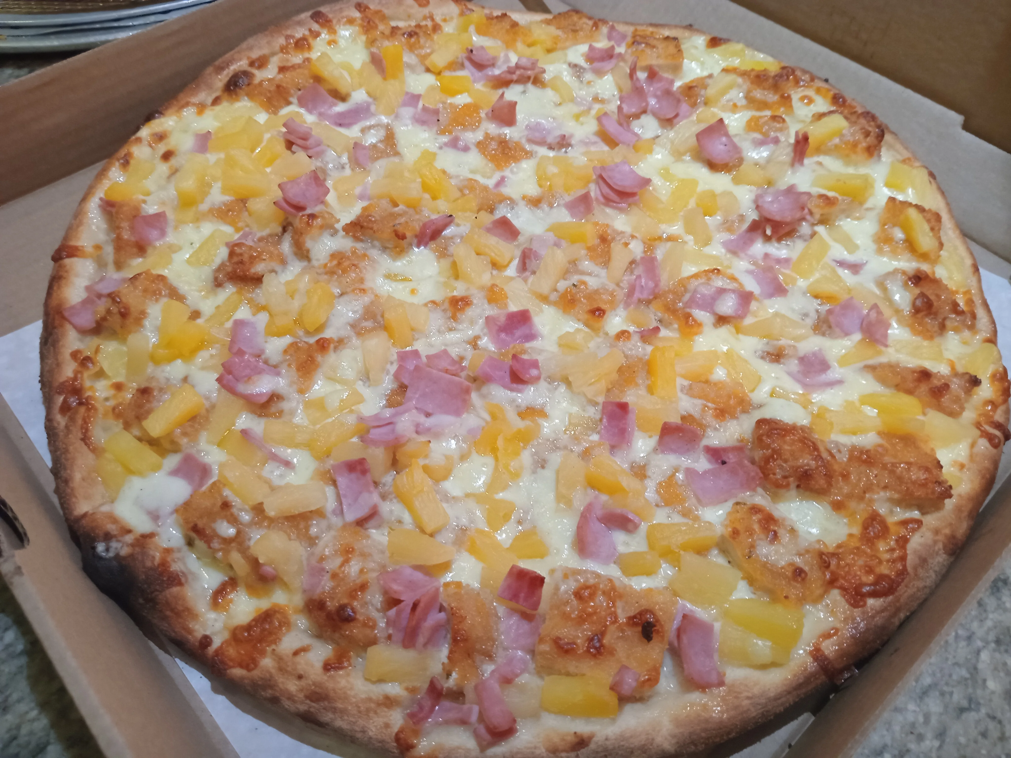 Hawaiian pizza topped with ham and pineapple