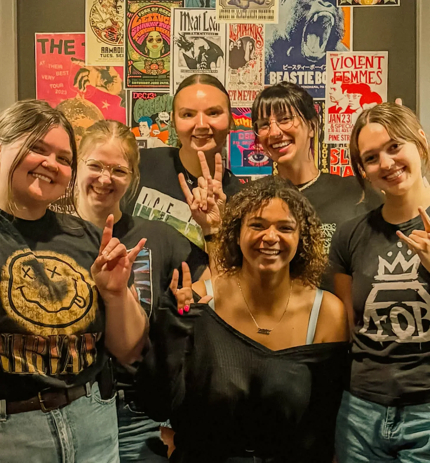 Staff posing together by our concert poster wall