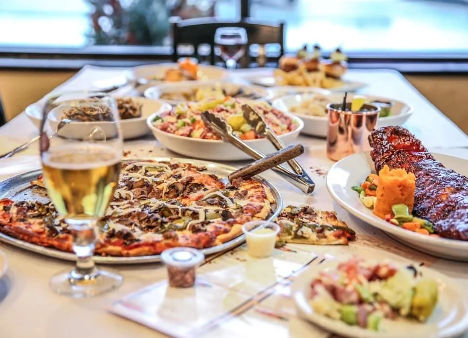 Assorted dishes including pizza and ribs on a dining table