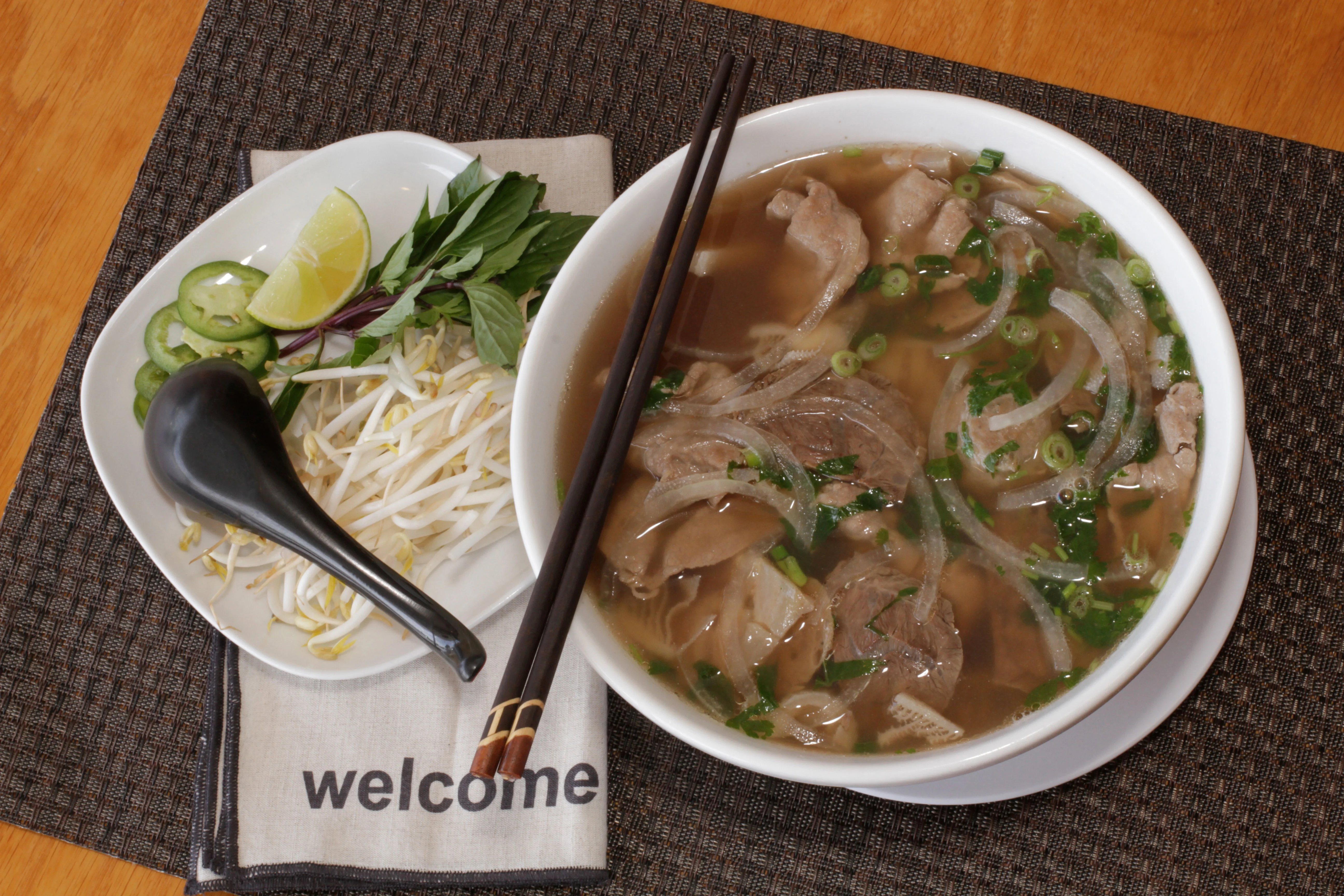 Bowl of Vietnamese pho with beef and fresh herbs