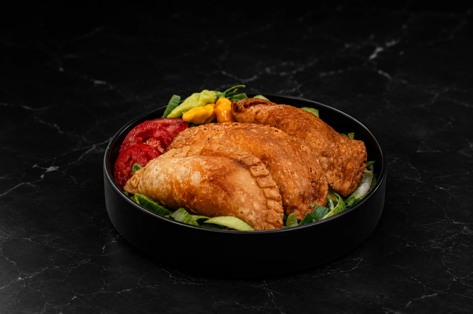 Golden Jamaican patties served with fresh vegetables
