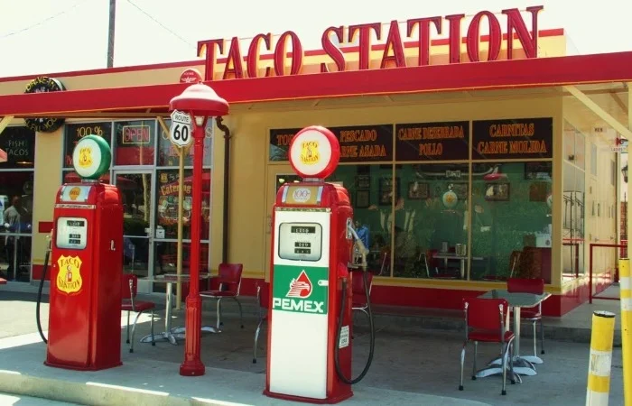 Taco Station restaurant exterior with vintage gas pumps
