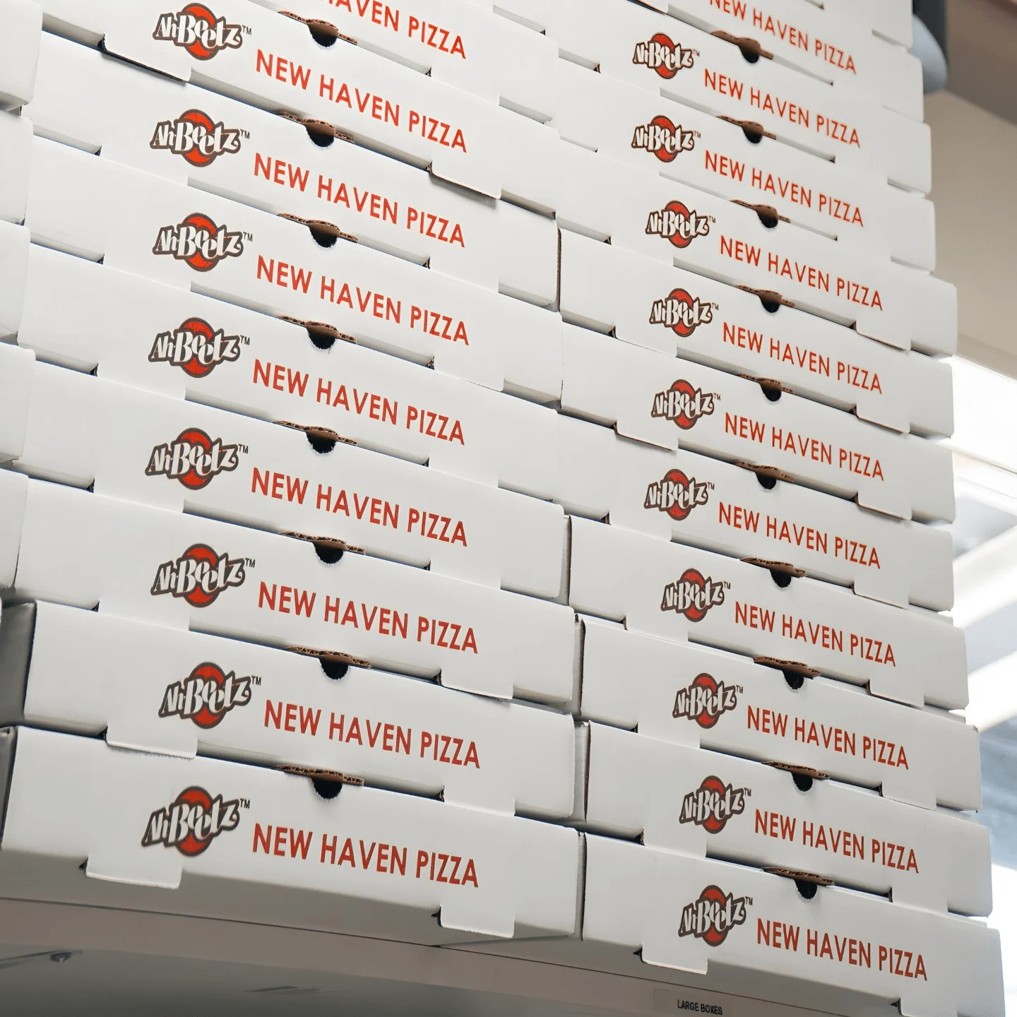 A stack of Ah Beetz pizza boxes