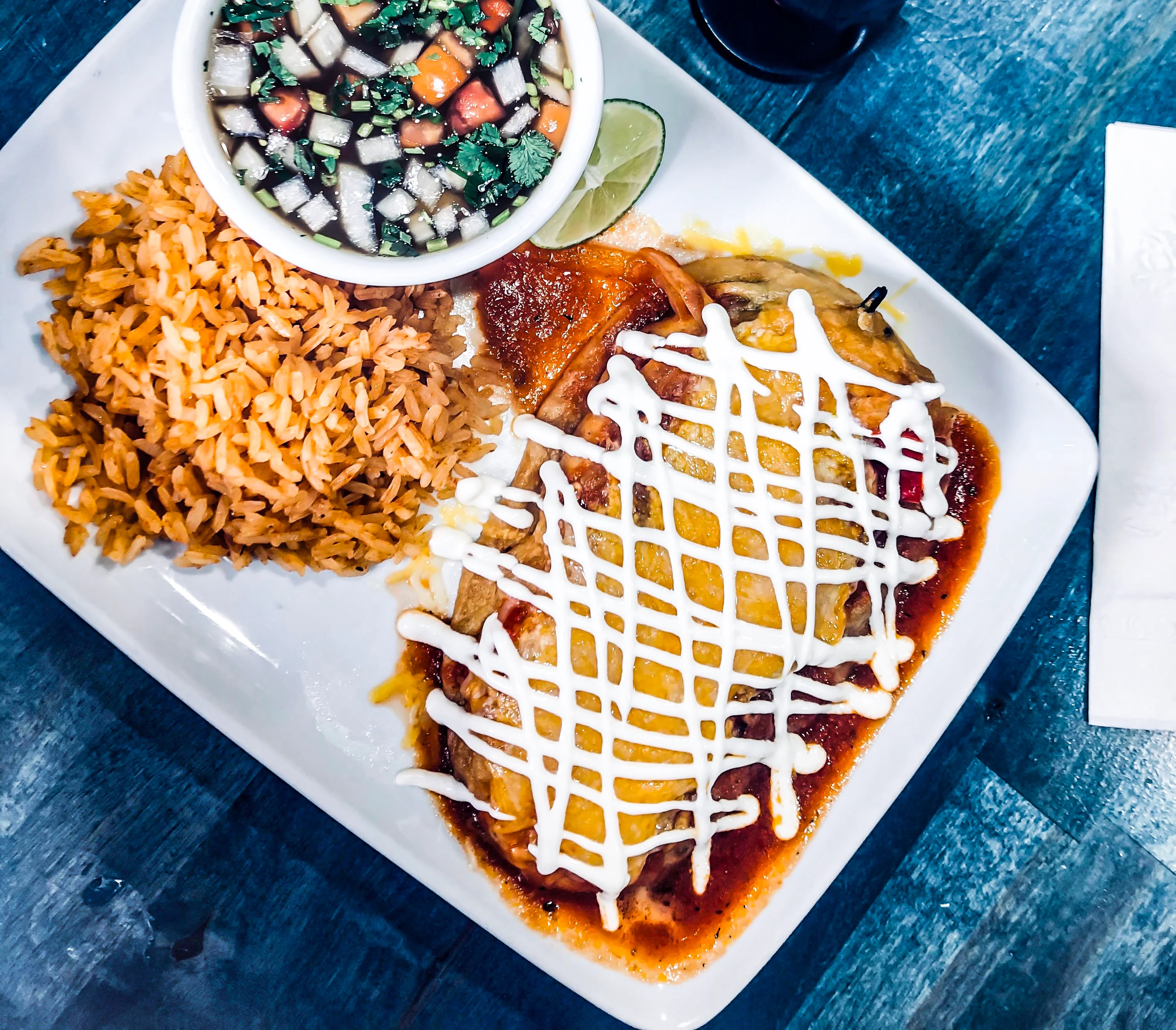Plate of enchiladas with rice and salsa in a Mexican restaurant