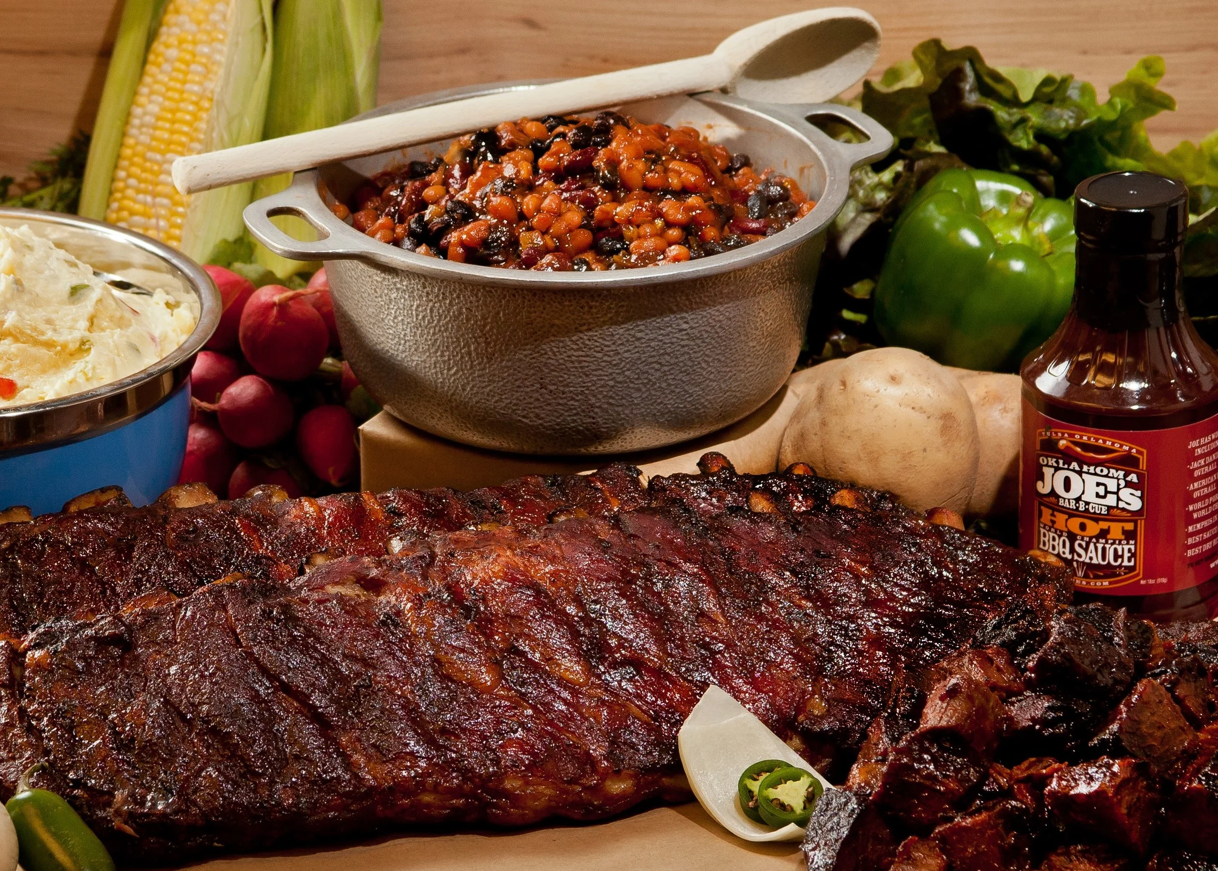 Barbecue ribs with baked beans and sides in a rustic setting