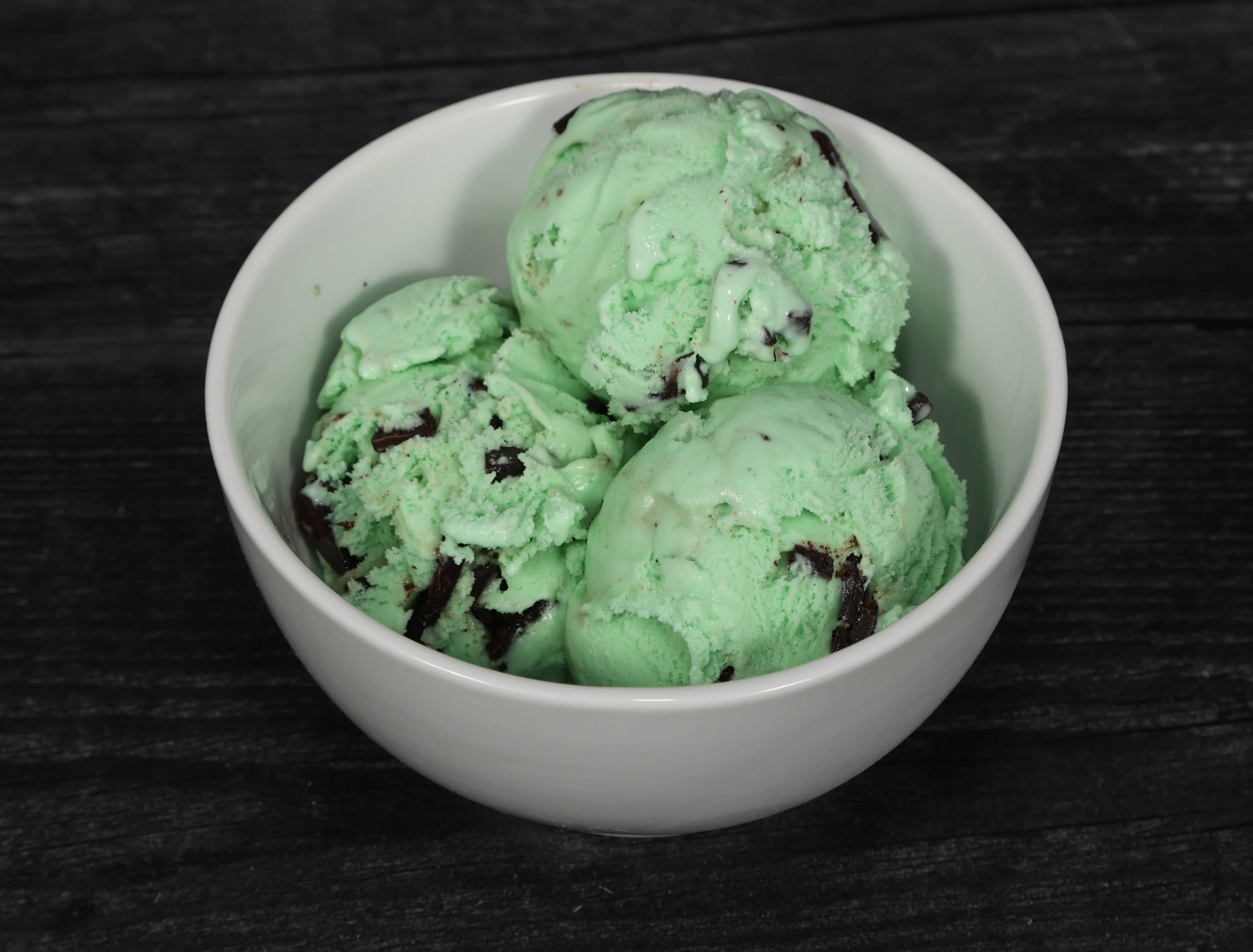 Mint chocolate chip ice cream in a bowl with a spoon